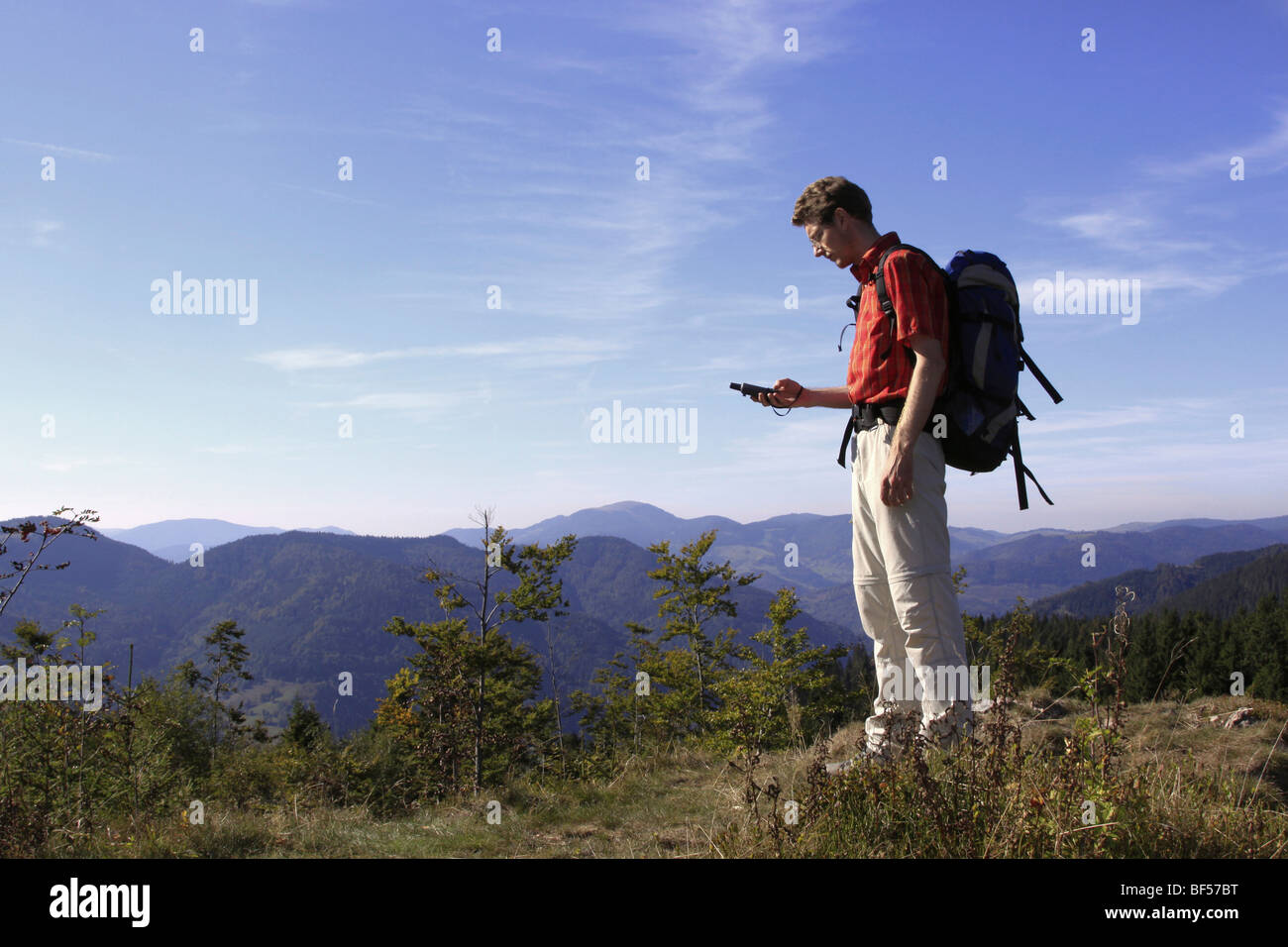 Geocacher checking the coordinates with a GPS navigation system on Mt. Leder Tschobenstein in Bernau in the Black Forest, Baden Stock Photo