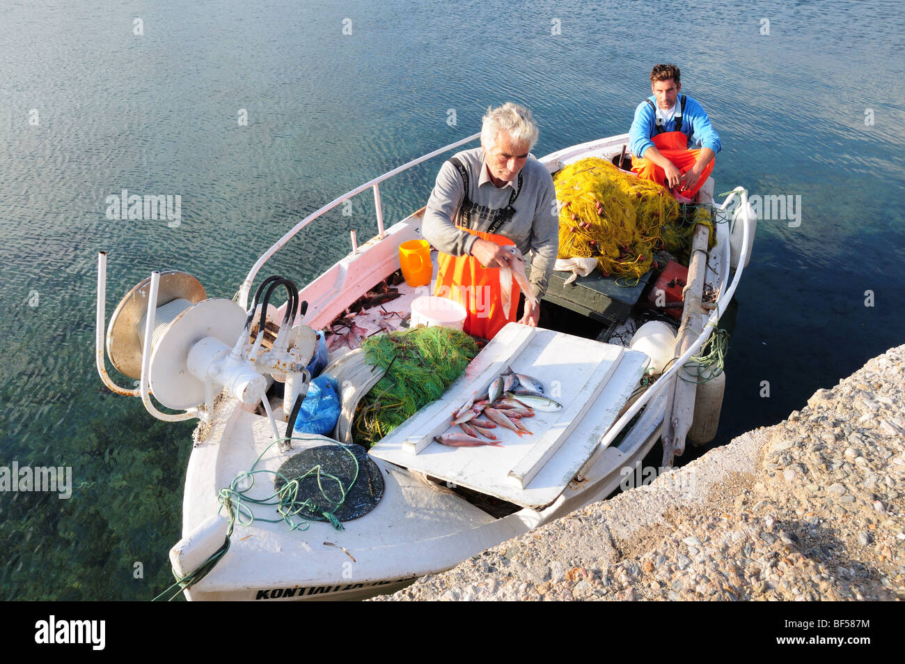 Two Greek fishermen in a small fishing boat  with their catch of fish Marmari Harbour Evia Greece Stock Photo
