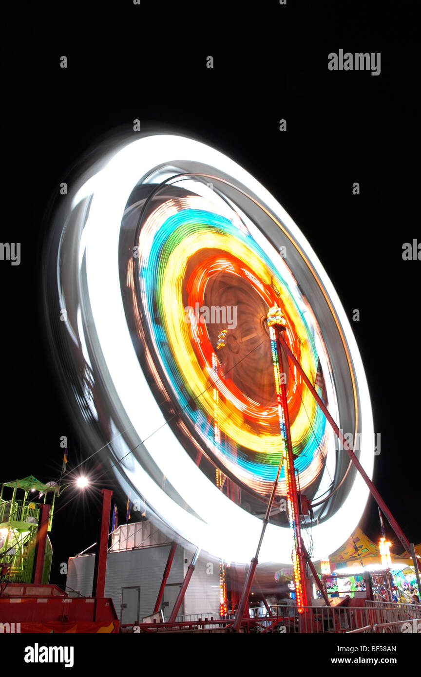 A Ferris wheel at a carnival at night showing motion blur Stock Photo ...