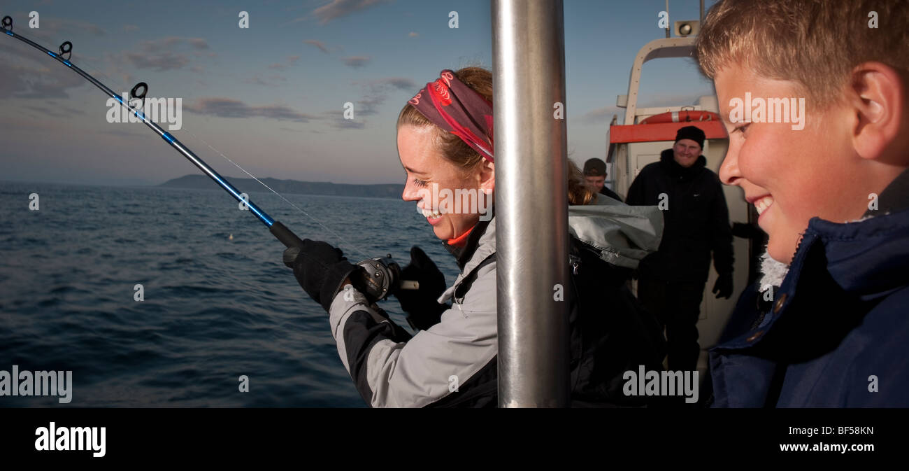 Mother and son fishing for cod, North Atlantic, Raufarhofn, Iceland Stock Photo