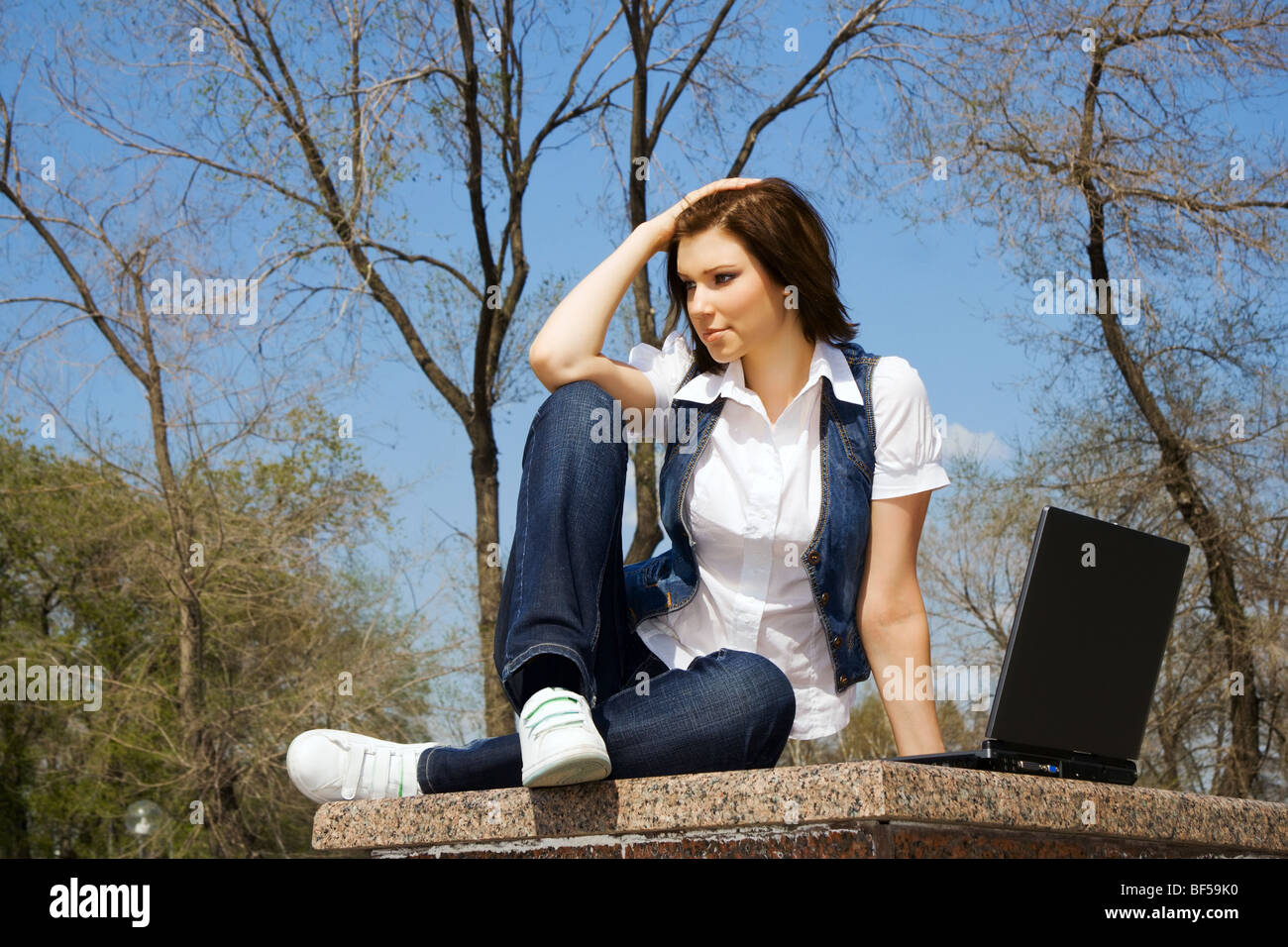 Young woman working on laptop in the city park Stock Photo - Alamy