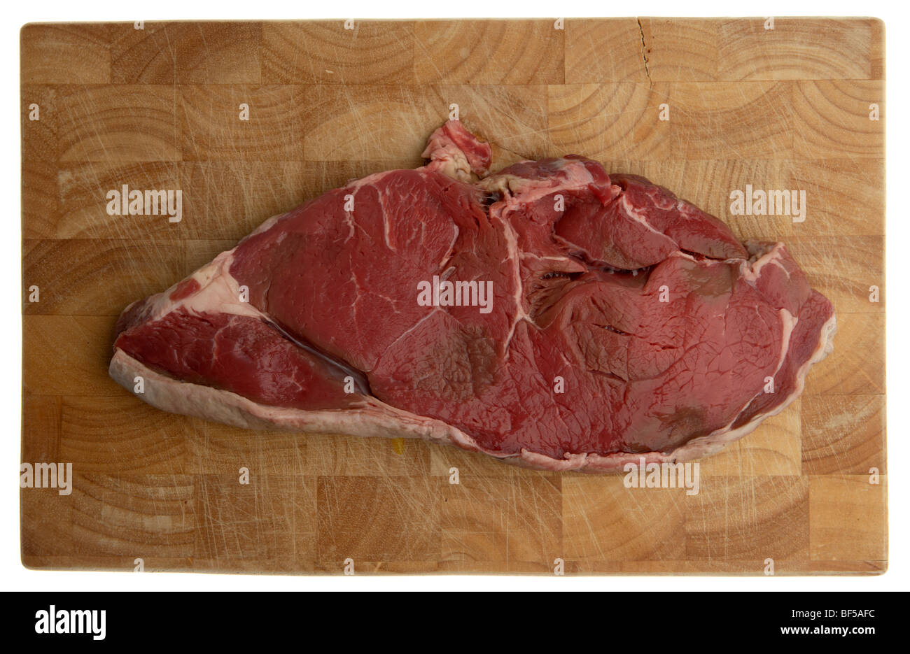 raw slice of chump steak from organic longhorn irish cows on a wooden butchers block Stock Photo