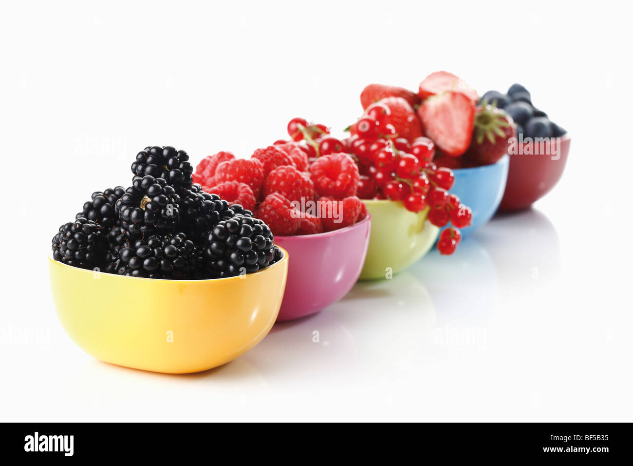 Forest berries, colorful dishes with wild berries, blueberries, blackberries, raspberries, currants, strawberries Stock Photo