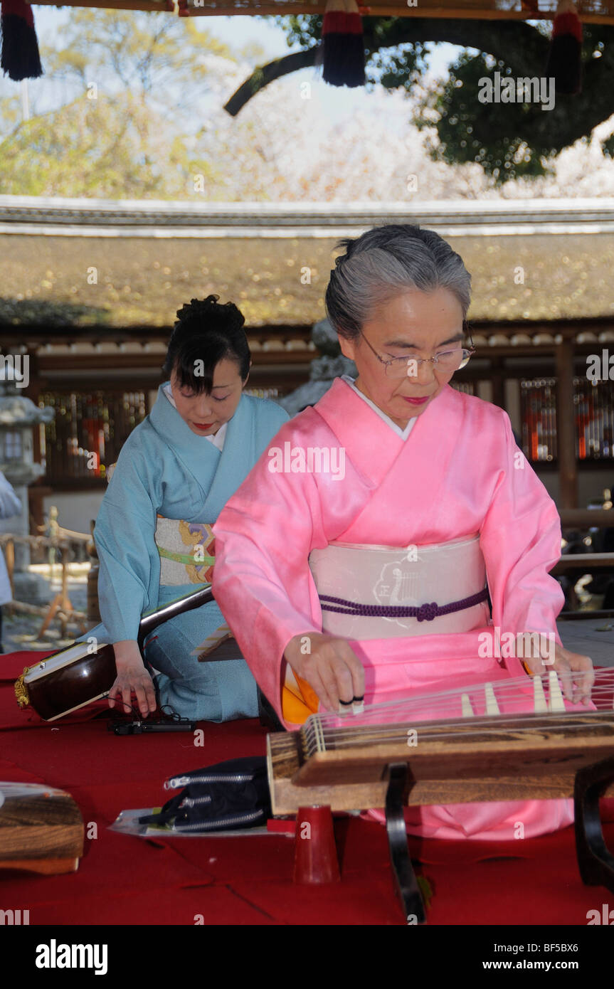 Woman playing a Koto, a traditional Japanese stringed musical