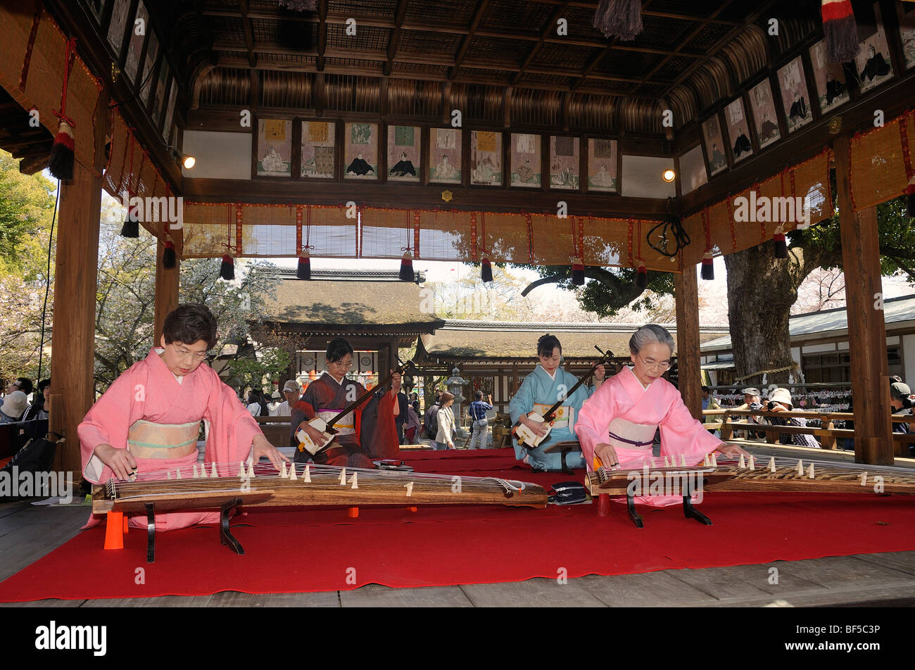 Women playing a Koto, a traditional Japanese stringed musical