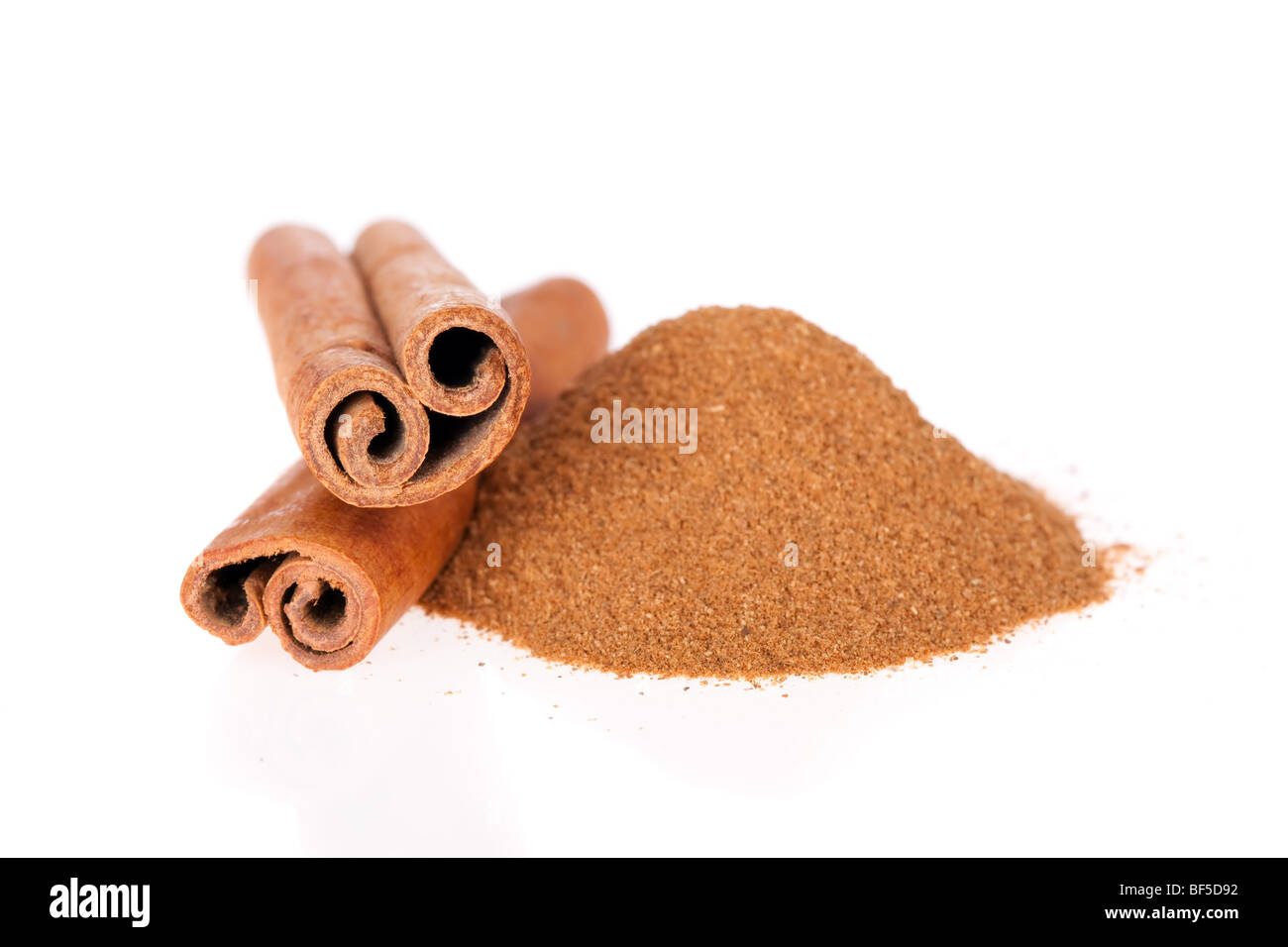 Ground cinnamon and sticks isolated on a white background Stock Photo