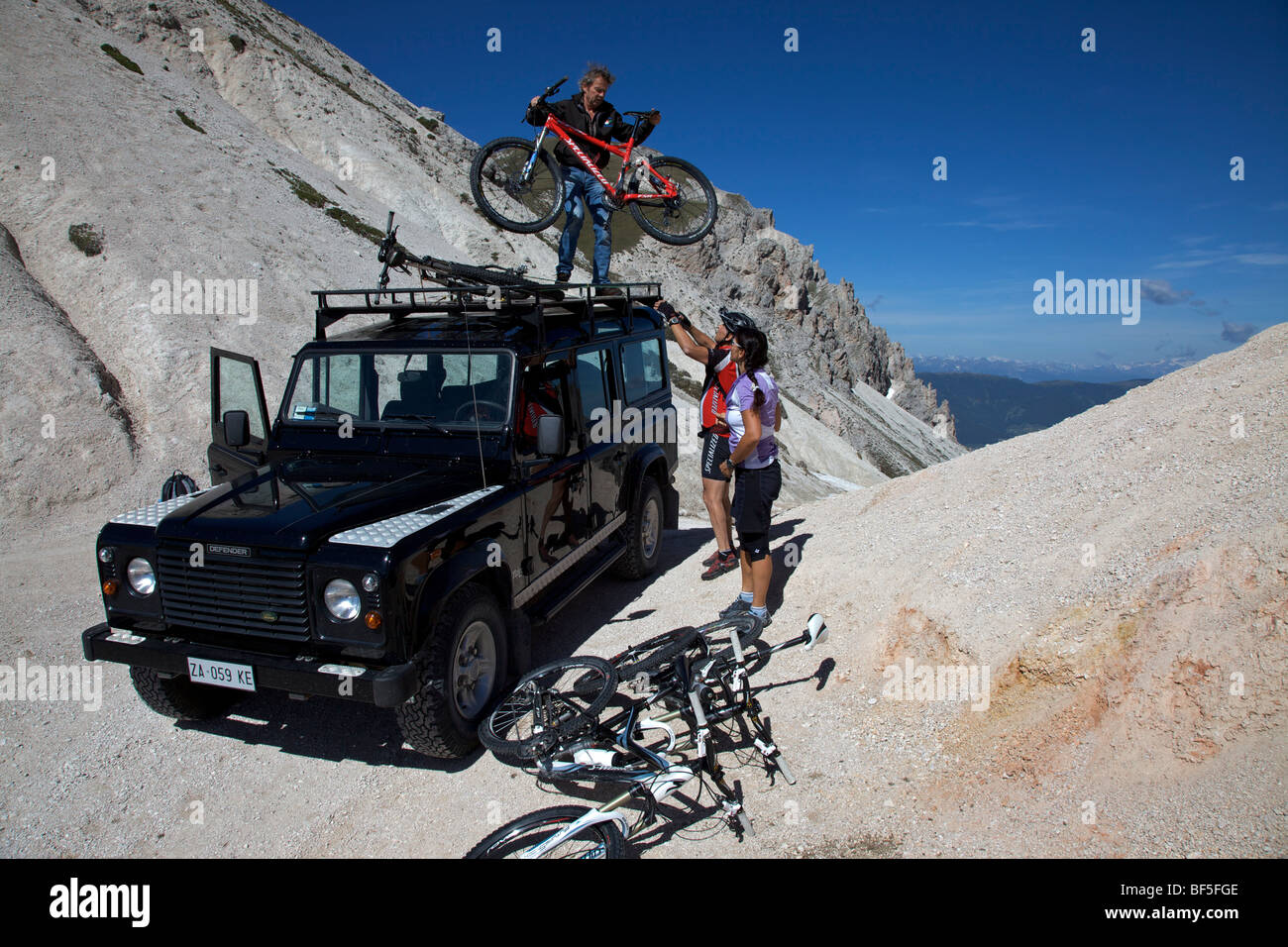 Mountain bike riders loading bicycles off a Landrover at the Kreuzjoch mountain gorge, Fodara Vedla basin, Parco naturale Fanes Stock Photo