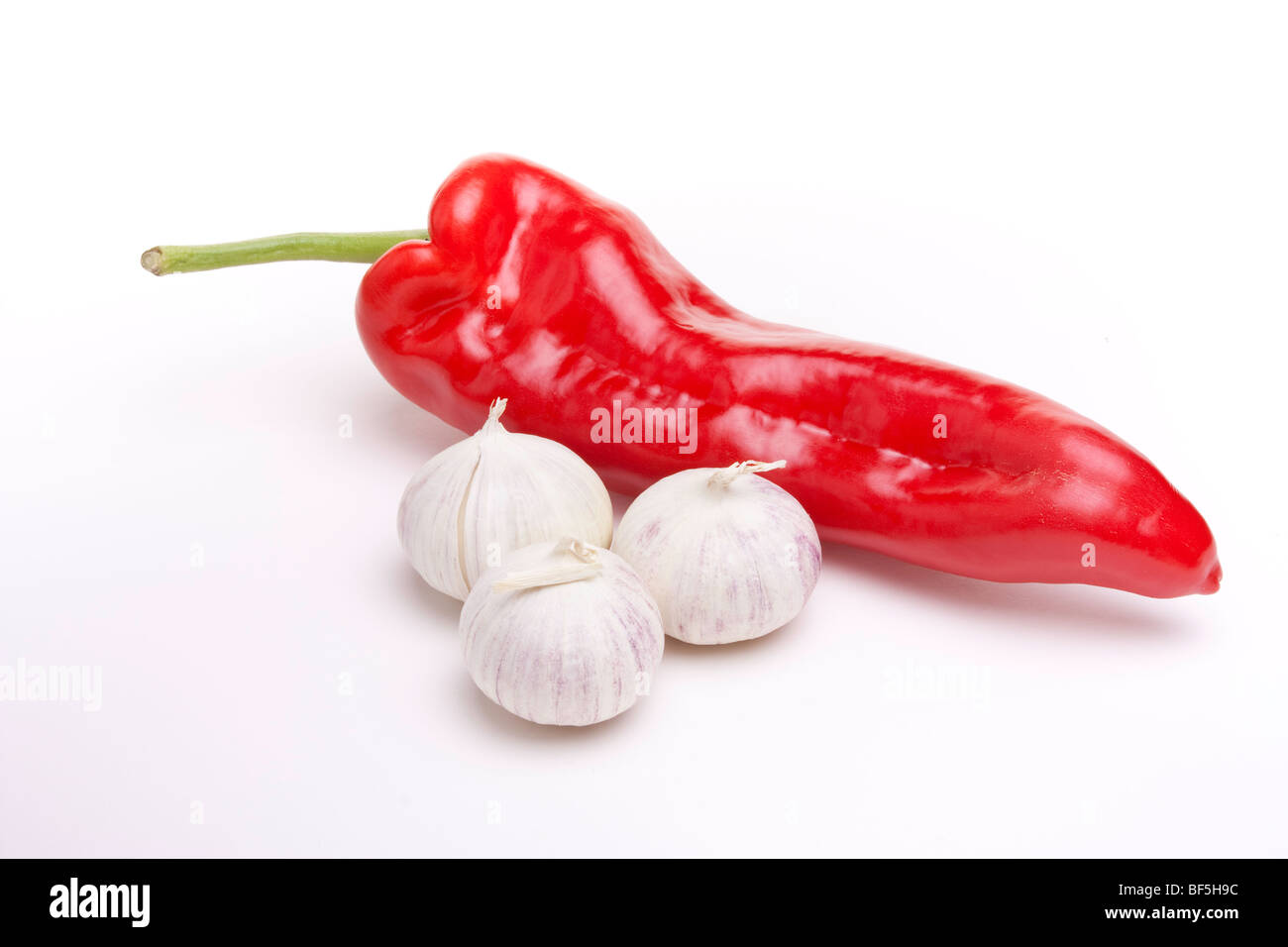 Large red sweet pepper and small italian garlic bulbs isolated against ...