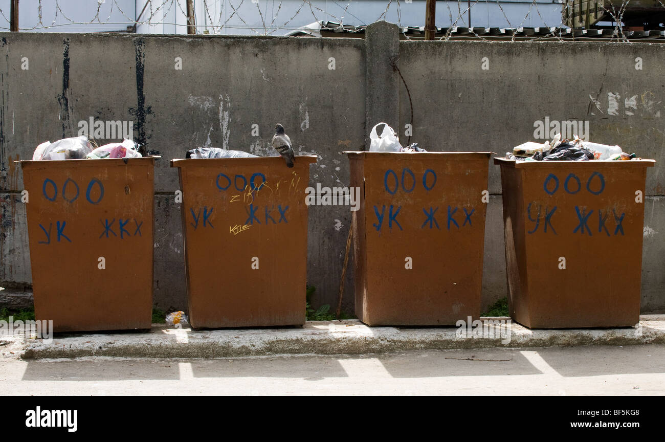 Row of bins with pigeon looking for food, Yekaterinburg, Russia Stock Photo