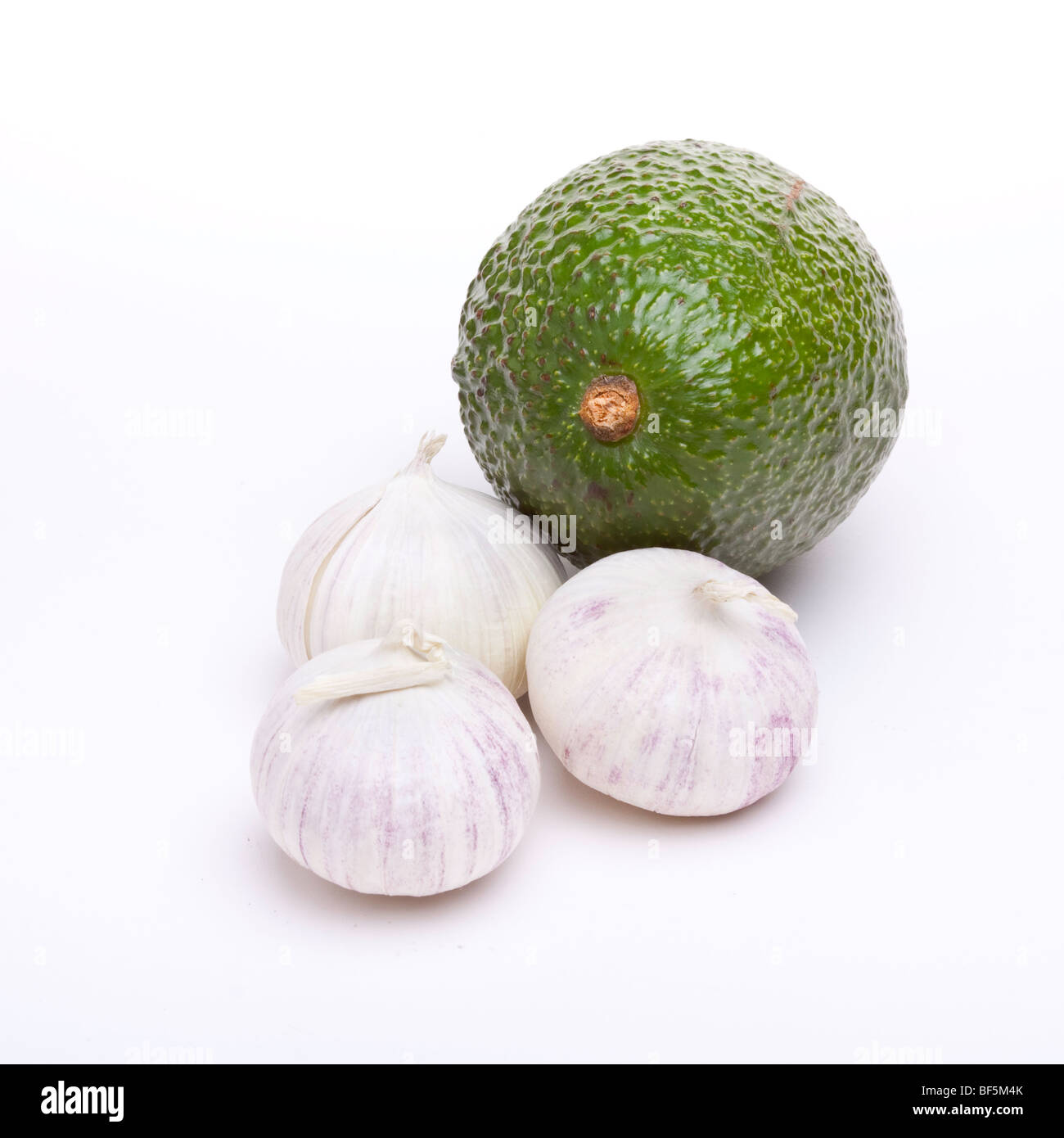 Small italian garlic bulbs and Avocado pear, the main ingredients of Guacamole. Isolated against white background. Stock Photo