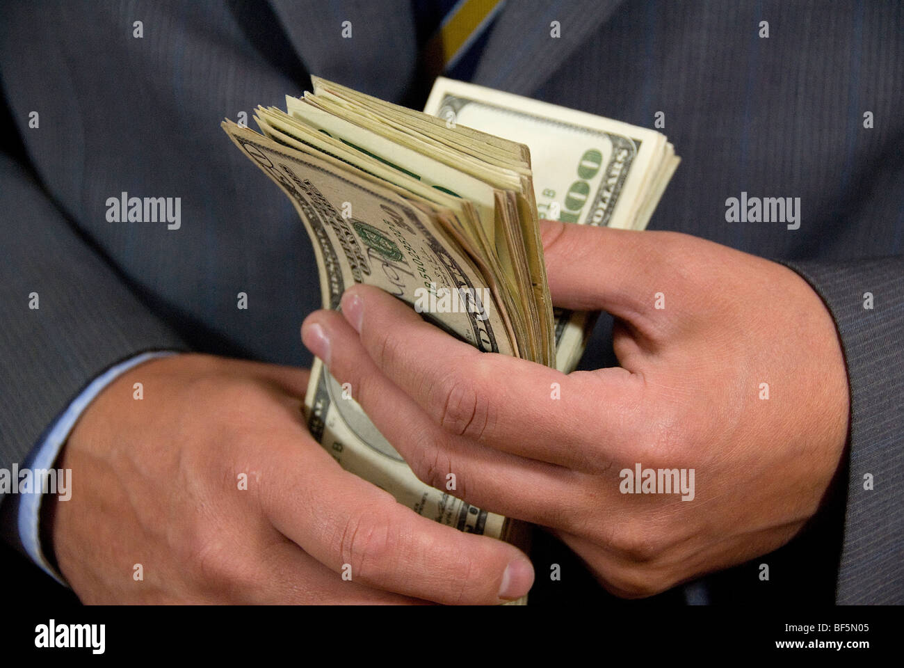 a holding a stack of 100 dollar bills Stock Photo