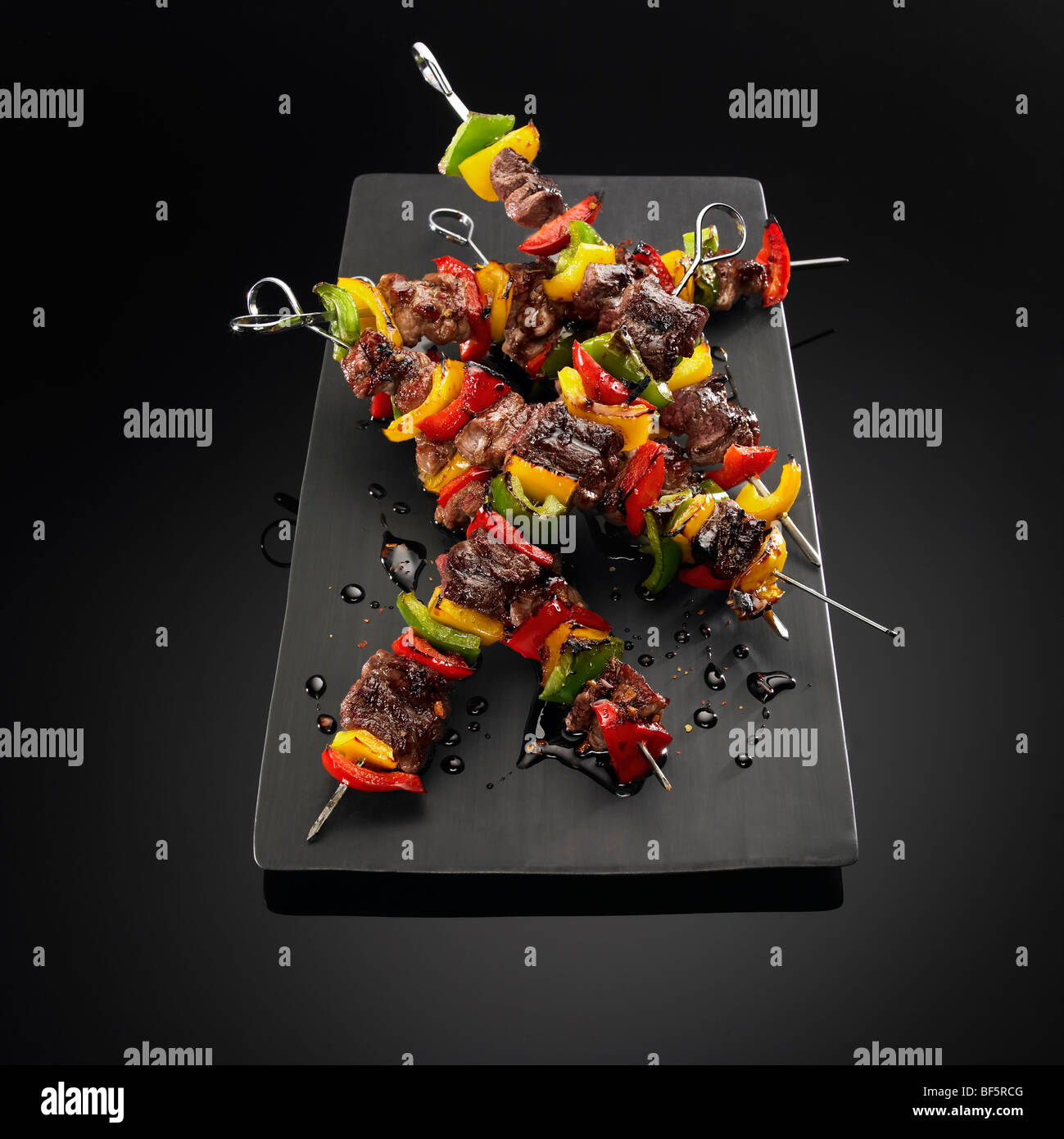 Beef and vegetable kebabs on skewers, on a black background. Stock Photo