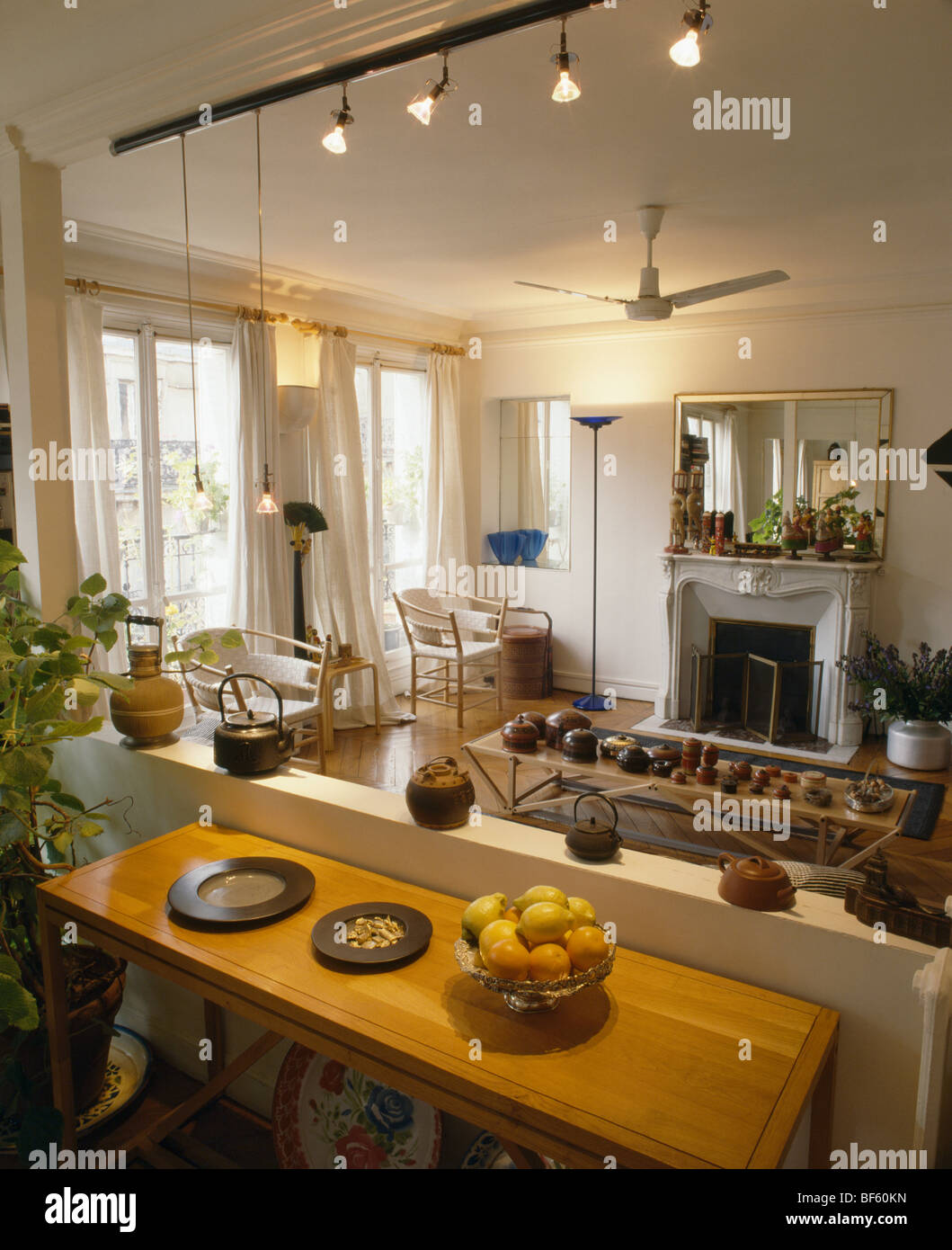 Track lighting in traditional French apartment living room with table in  front of low partition wall Stock Photo - Alamy