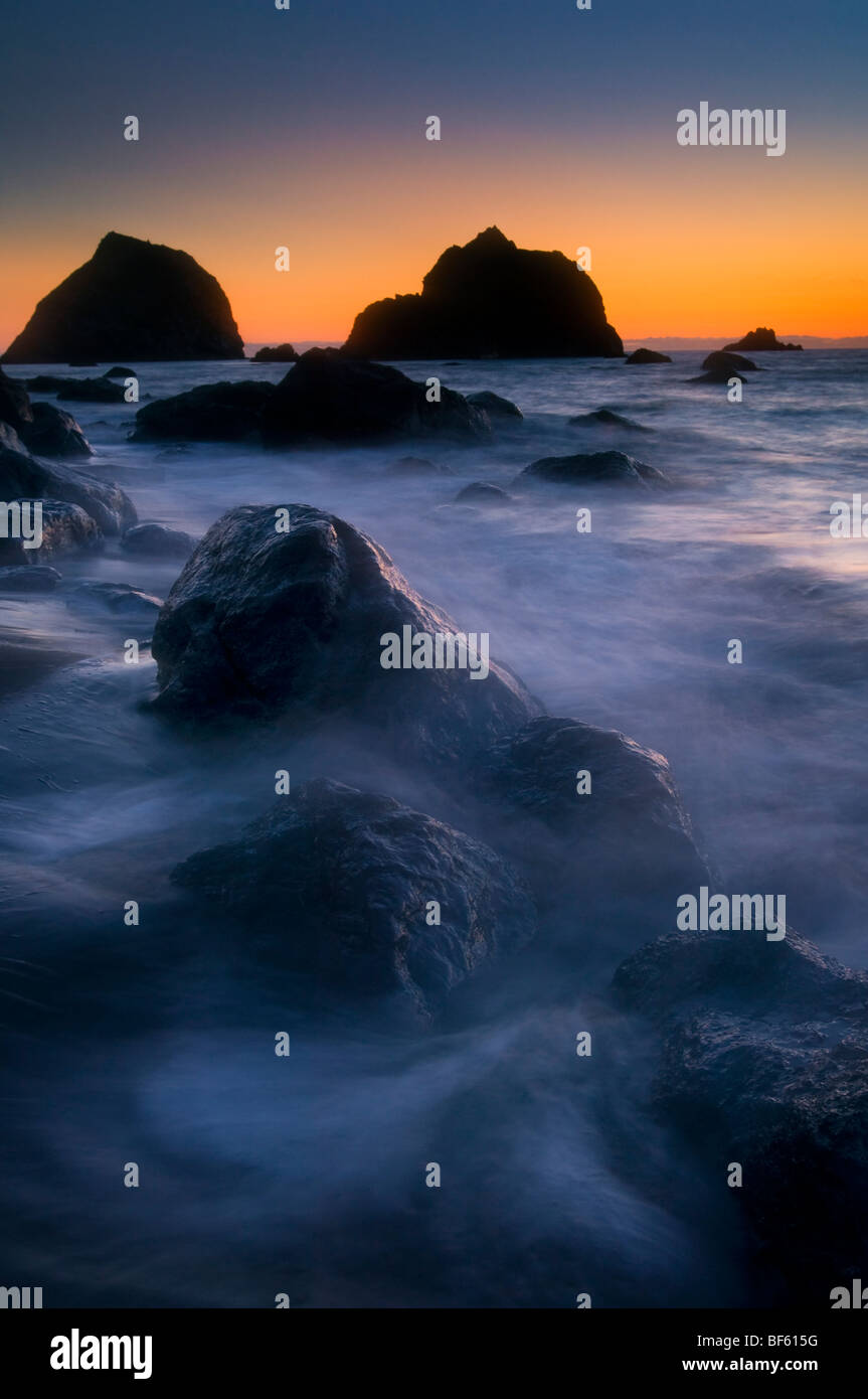 Sunset light over seastacks and coastal rocks on beach at False Klamath Cove, Redwood National Park, California Stock Photo