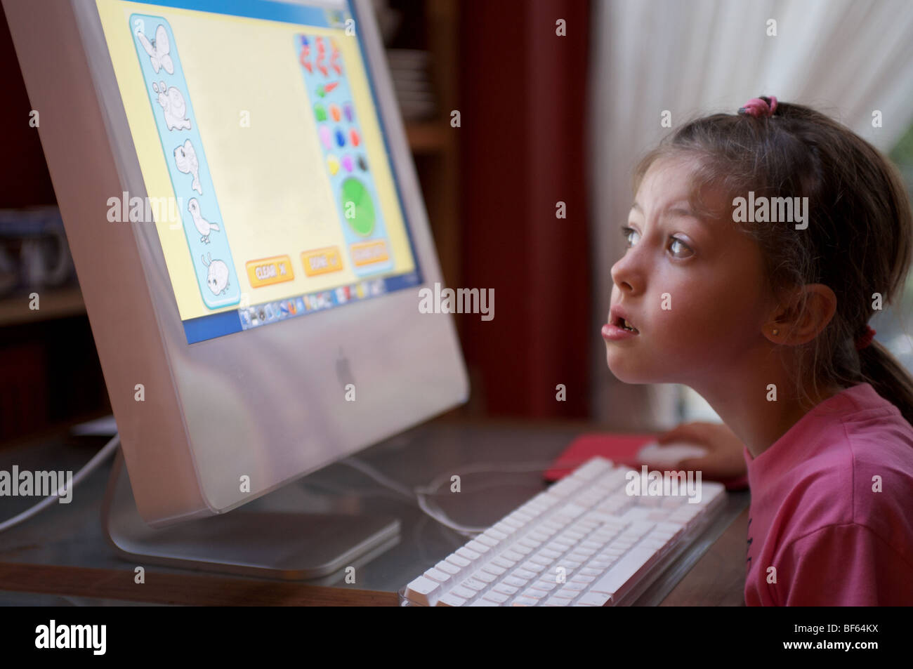 Young girl playing video games on computer after online school Stock Photo  by DC_Studio