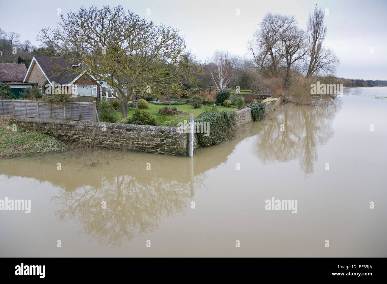 Houses and gardens sit precariously alongside the flooded River Arun, Pulborough, West Sussex, England. Stock Photo