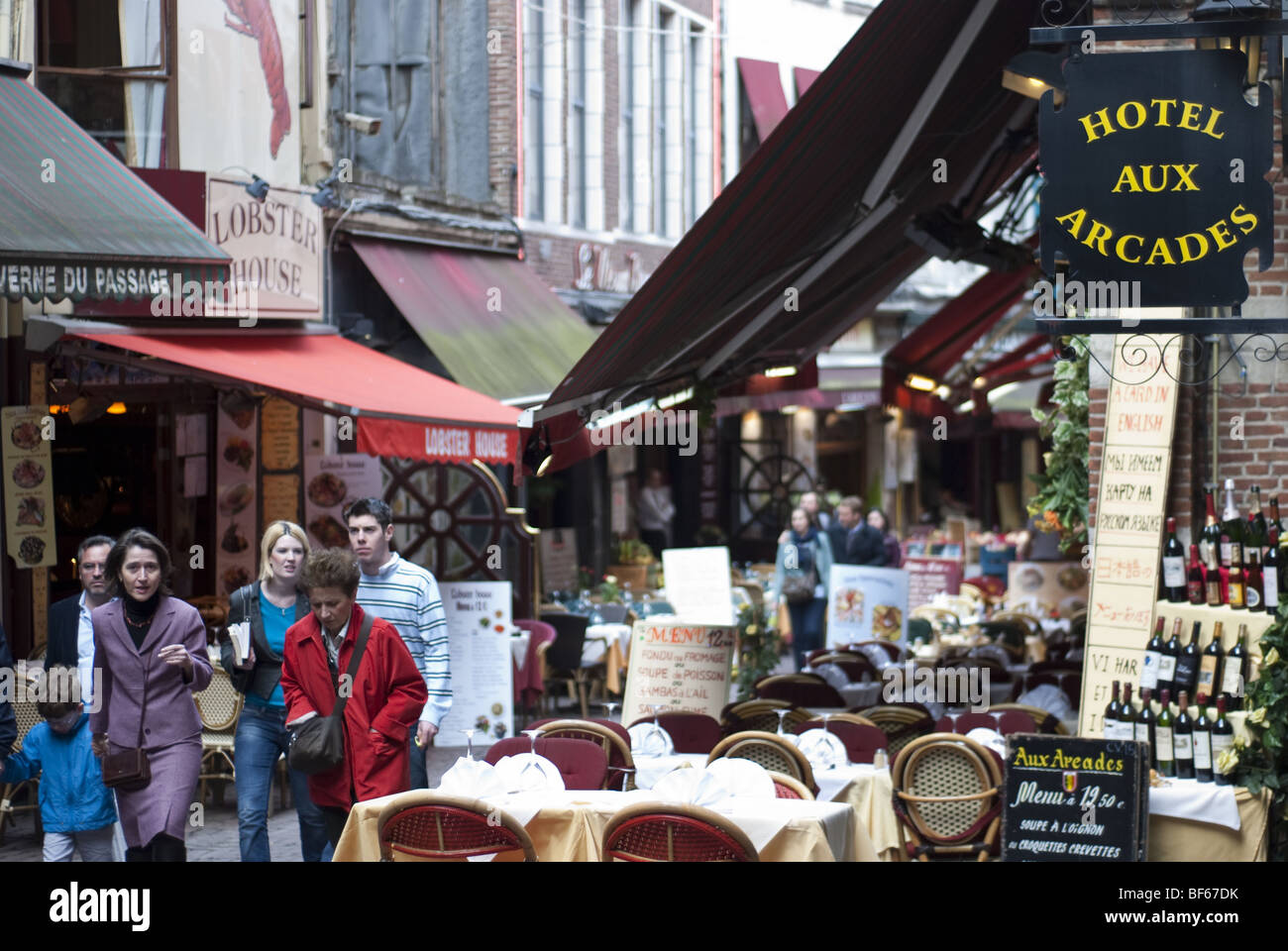 Tourists walk past the many restaurants of Rue des Bouchers in Brussels, Belgium. Stock Photo