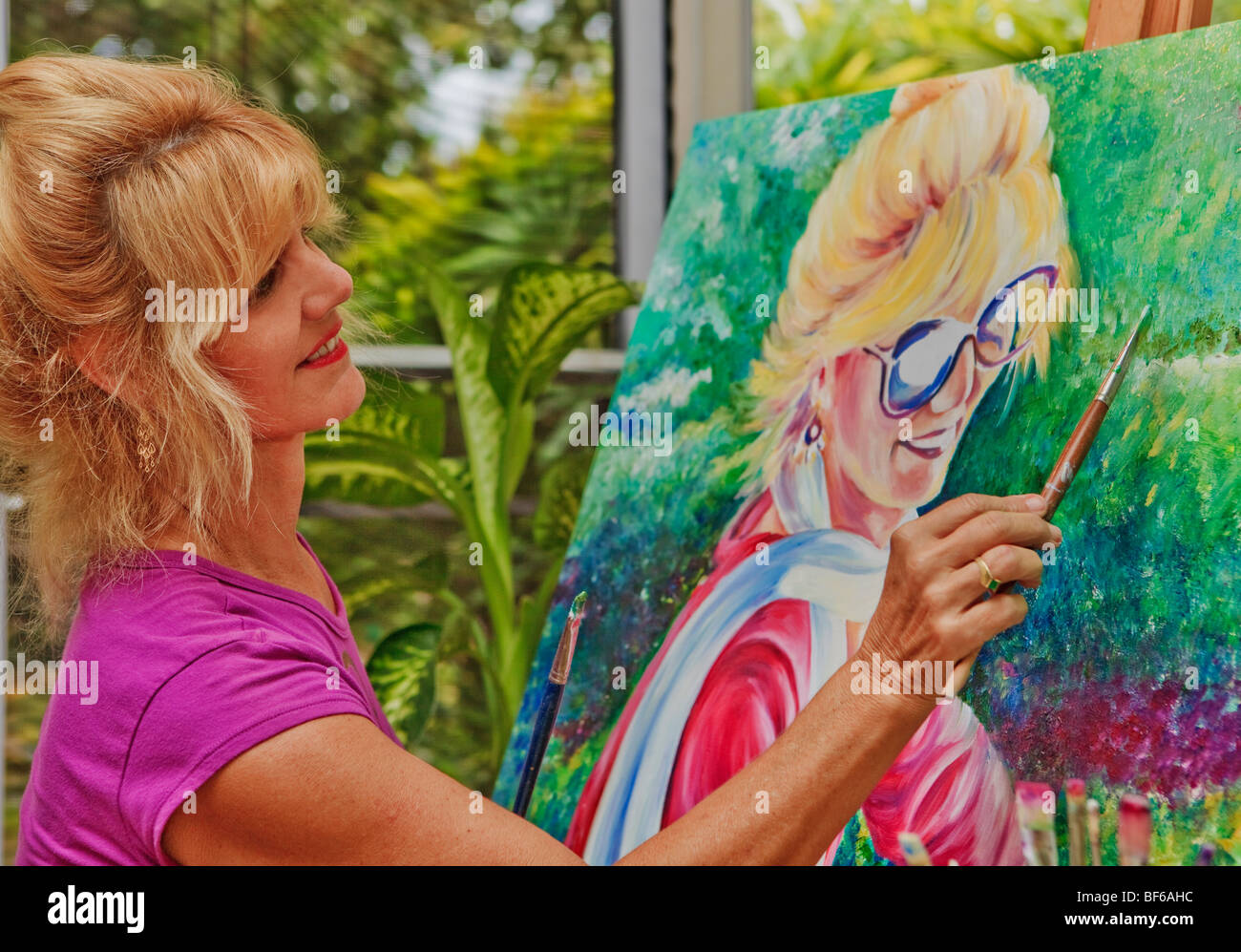 Female artist painting a self portrait Stock Photo