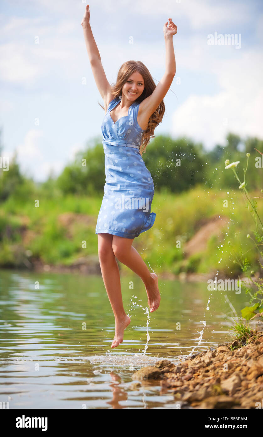 Young woman jumping on a river bank Stock Photo - Alamy