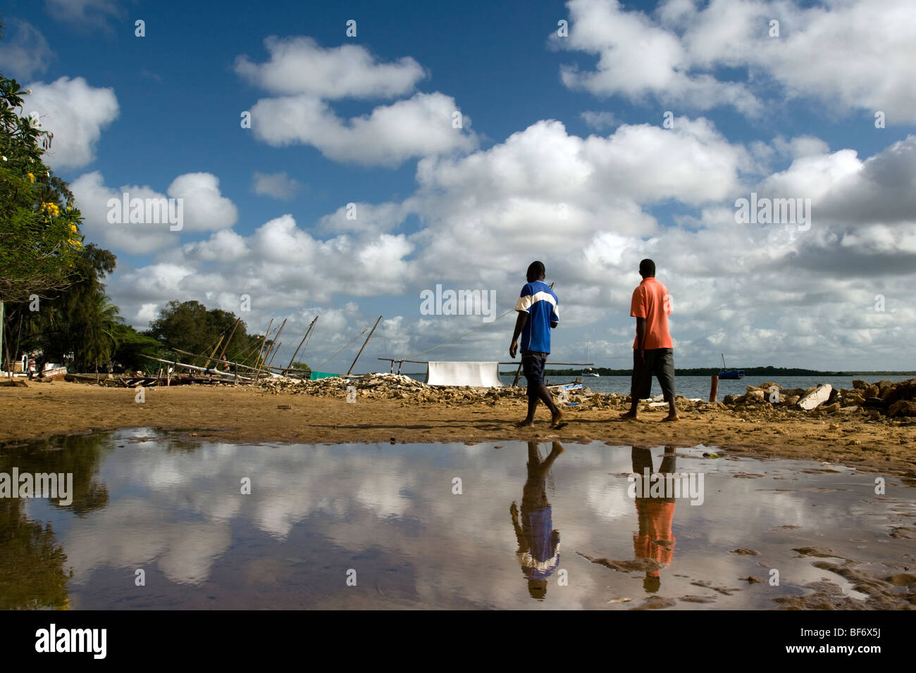 People walking near shoreline - Lamu Island, Kenya Stock Photo