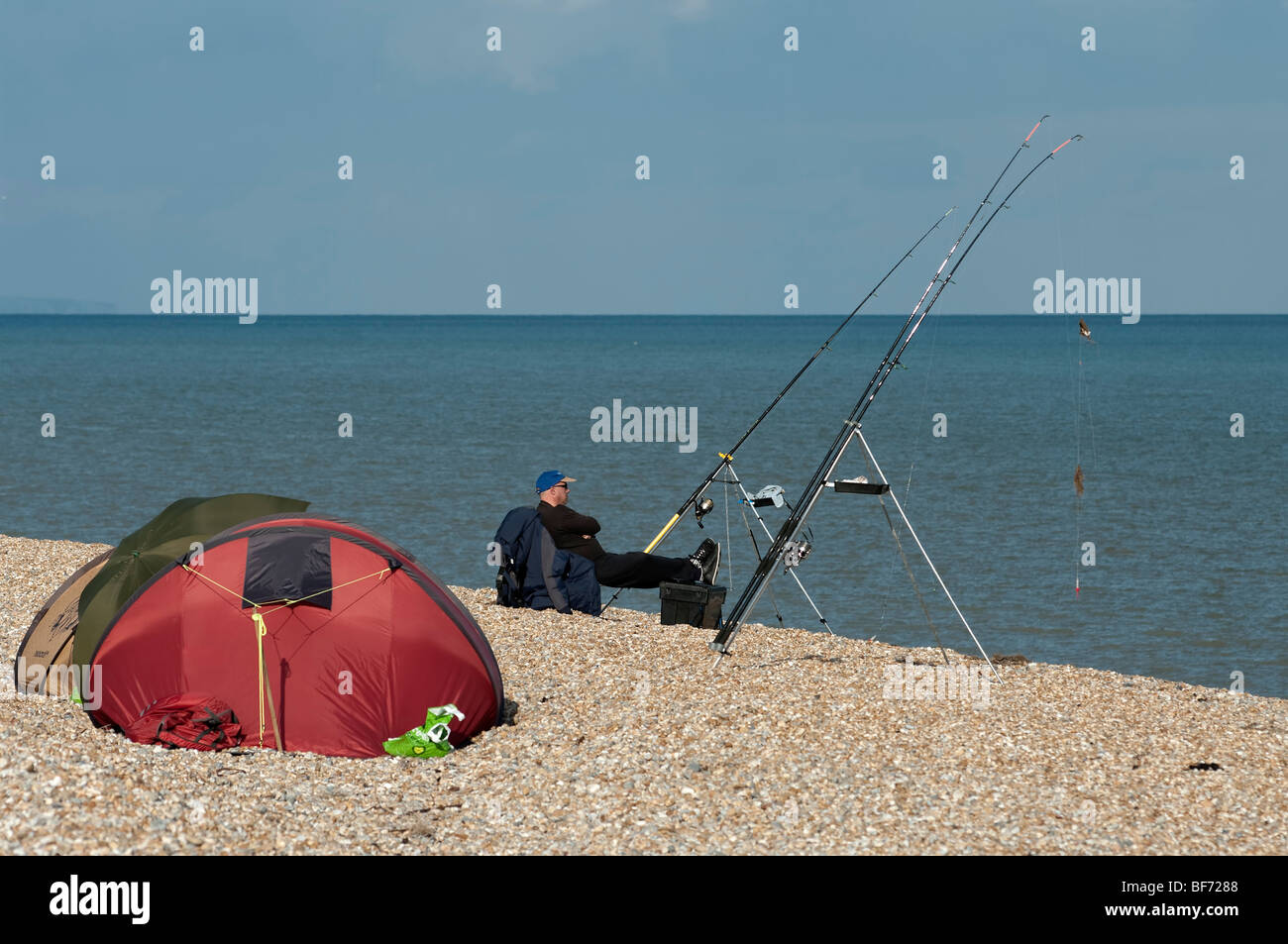 Sea angler waits to catch fish at Dungeness, Kent, England Stock Photo Alamy