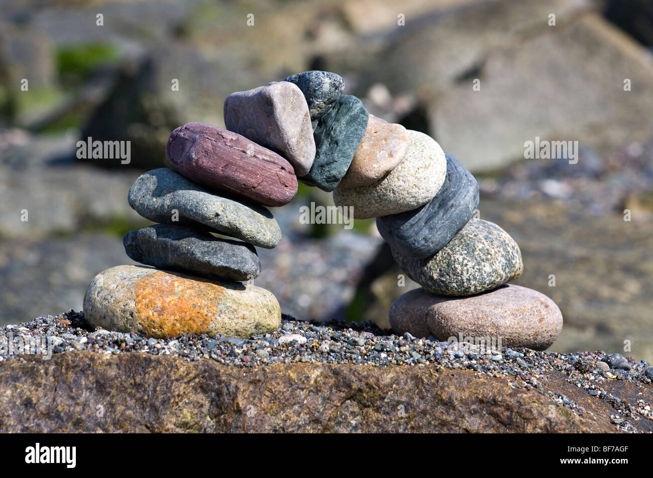 Balanced Stones in an arch on a large rock. Stock Photo
