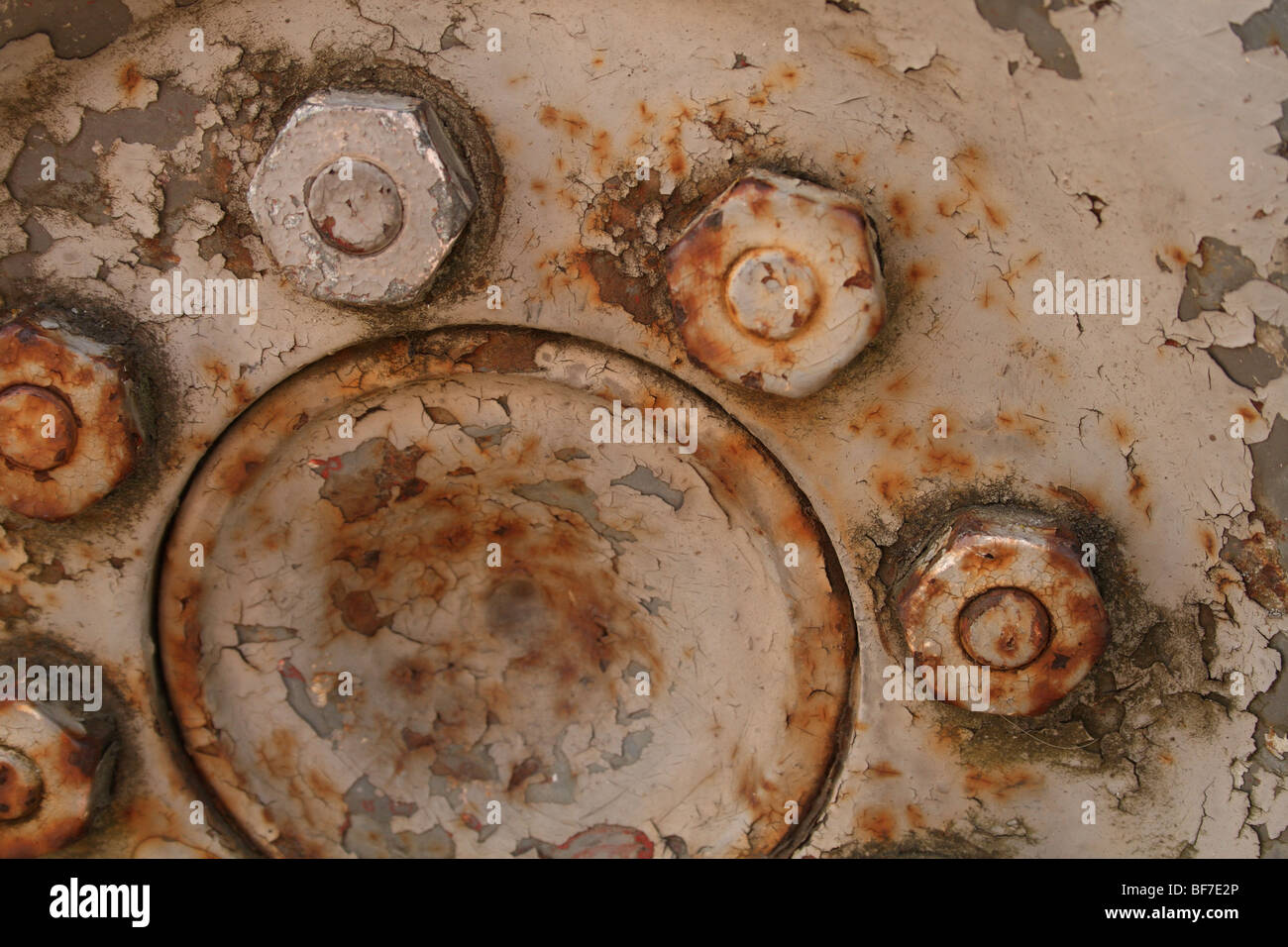 Rusty steel wheel nuts on old Massey Ferguson tractor wheel hub at
