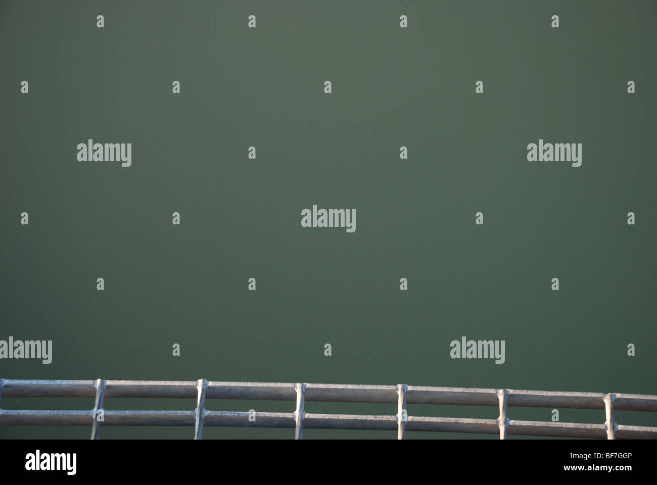 Metal grid above green water Stock Photo
