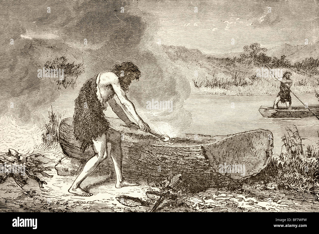 A prehistoric man using fire to fashion a canoe from a log Stock Photo