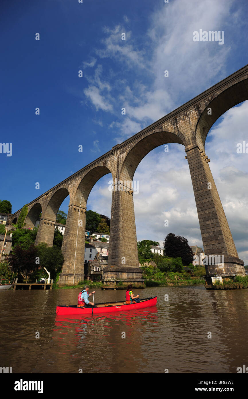A man and a woman canoeing and kayaking on the river Tamar, on the Devon and Cornwall border, UK, in the village of Calstock Stock Photo