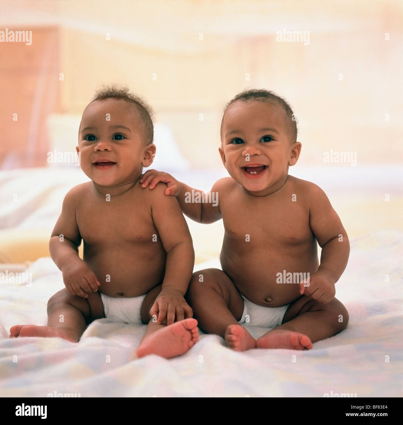 Spanish twin baby boys sitting on blanket Stock Photo