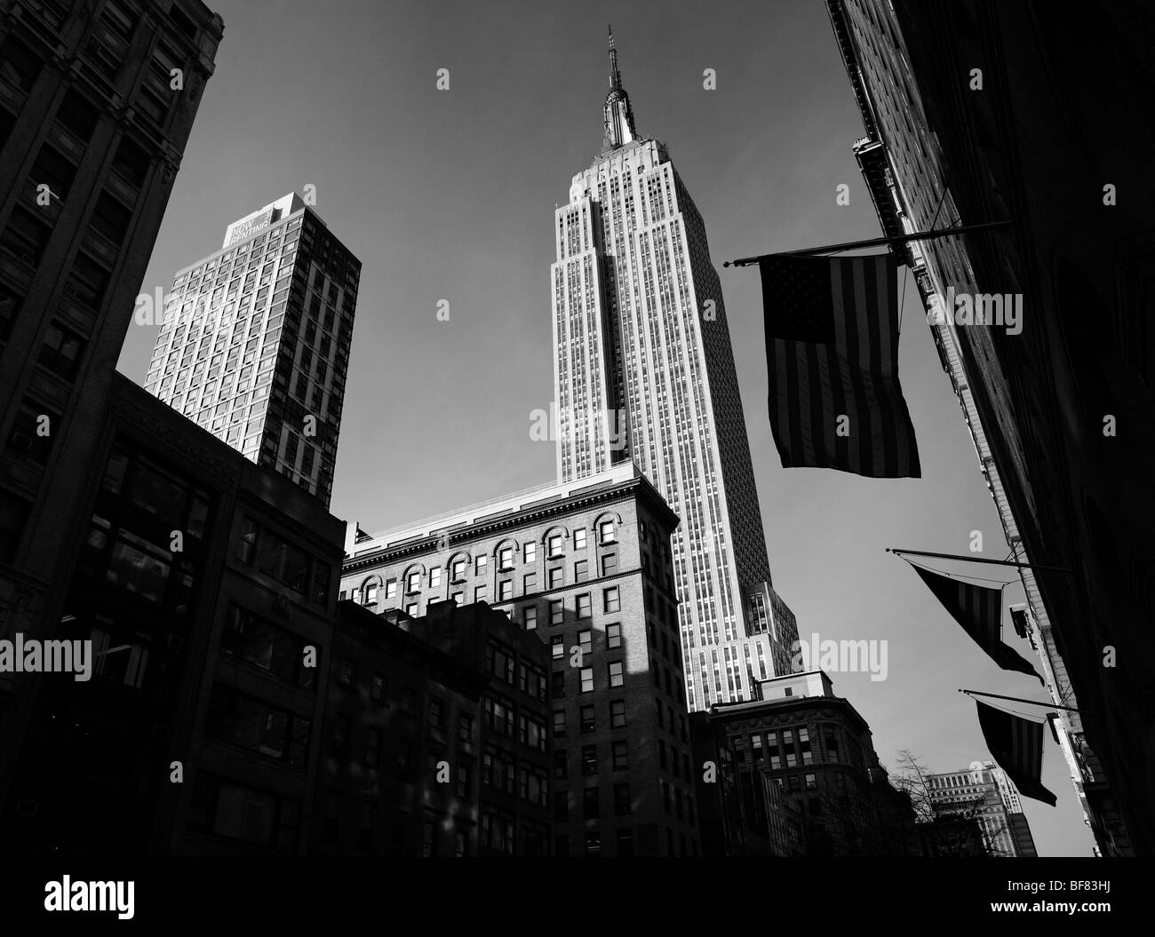 The Empire State Building with stars and stripes flags in black and white, Manhattan, New York City, USA Stock Photo