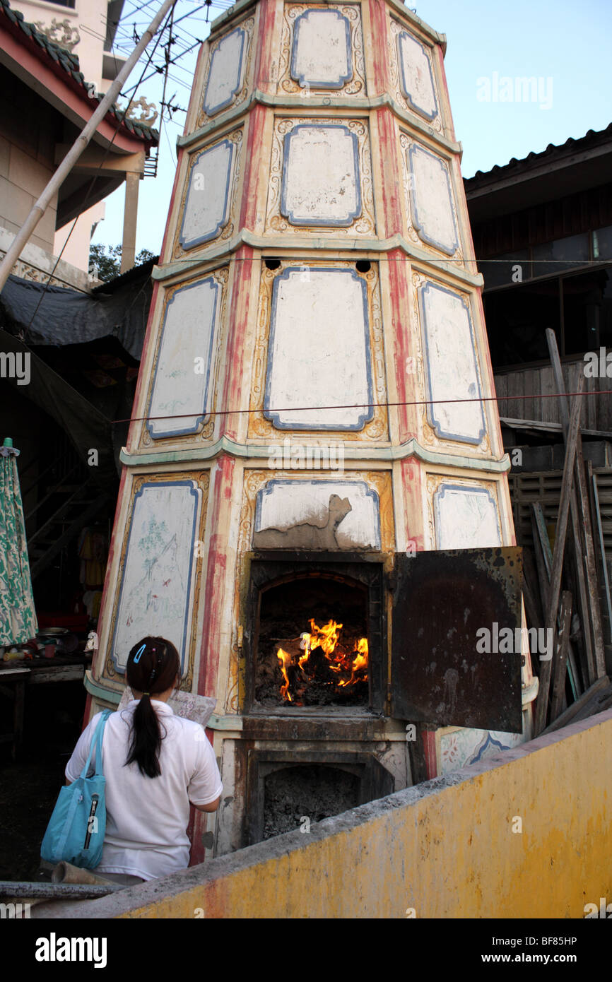 A Woman burning joss paper , Vegetarian Festival at Chinese Temple at Bangkok 's Chinatown Stock Photo
