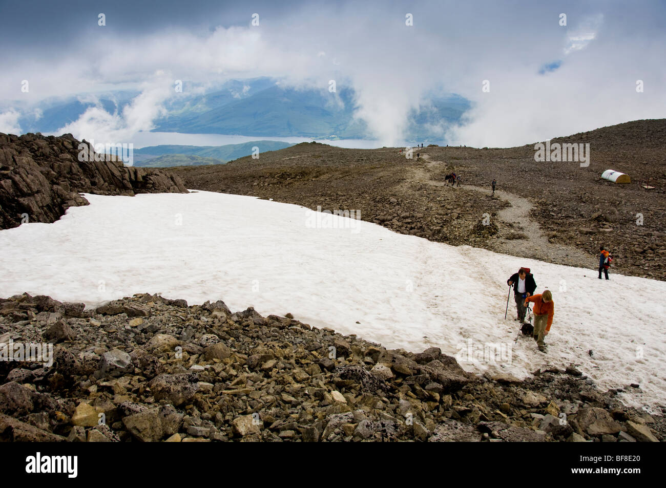 Snow near summit of Ben Nevis, the UK's highest mountain with Loch Eil in the distance. Scotland. Stock Photo