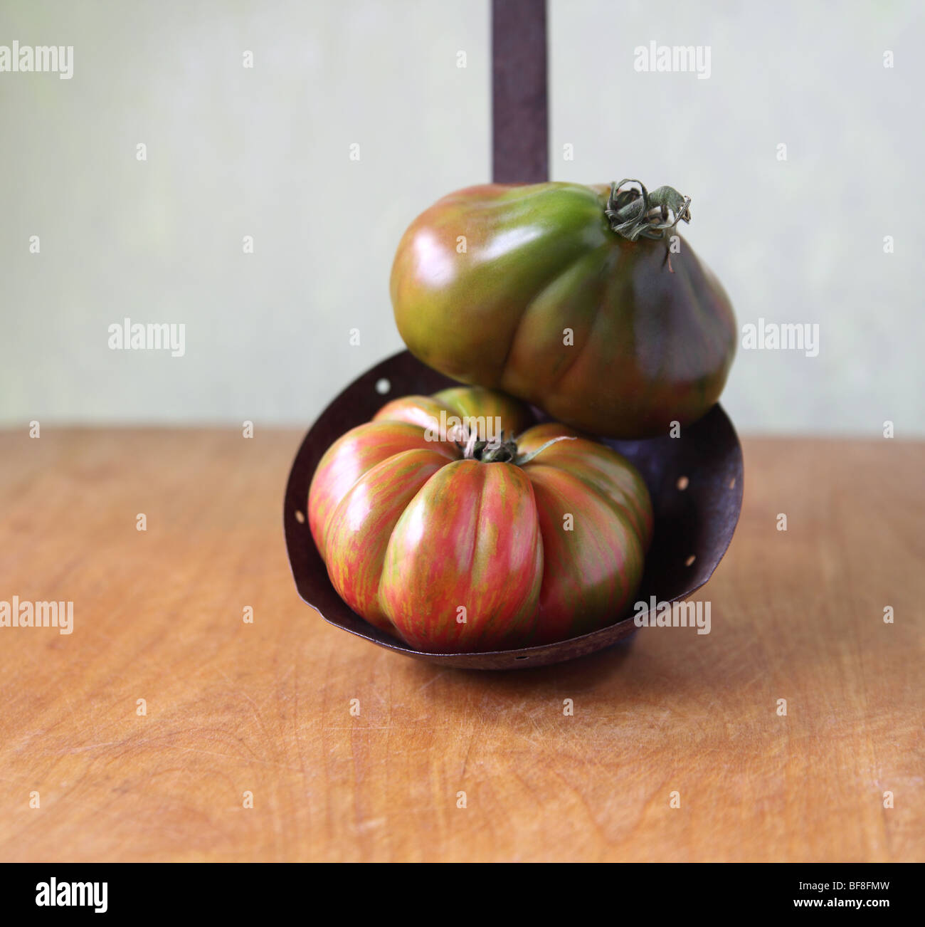 heirloom tomatoes on an antique ladle Stock Photo