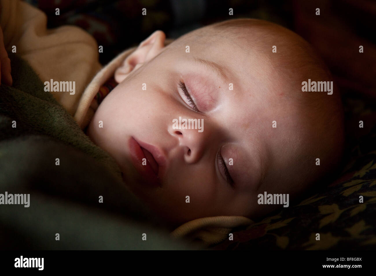 6 month old baby boy sleeping in dappled natural light, Hampshire England. Stock Photo