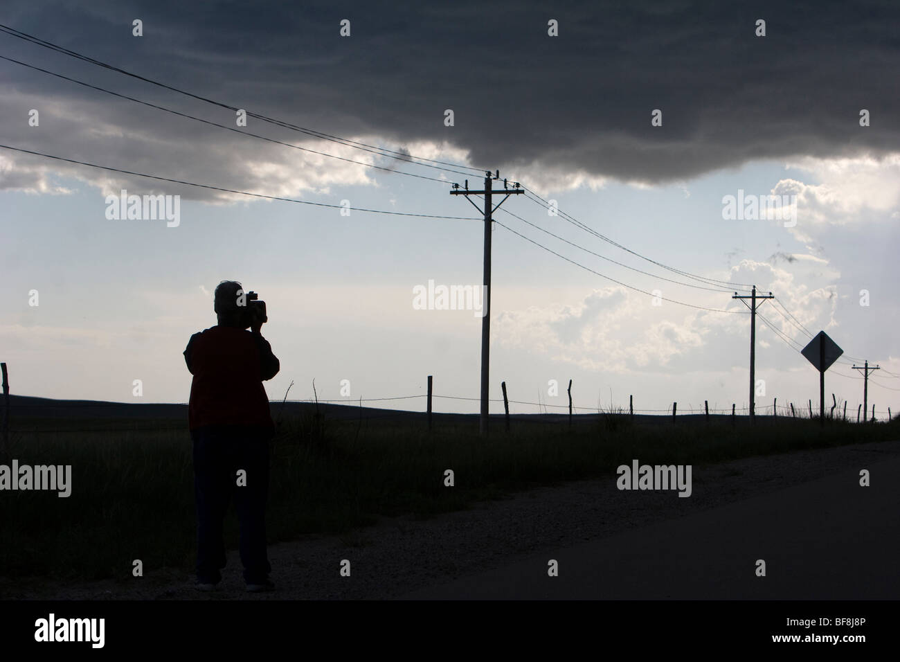 A cameraman films during a thunderstorm. Stock Photo