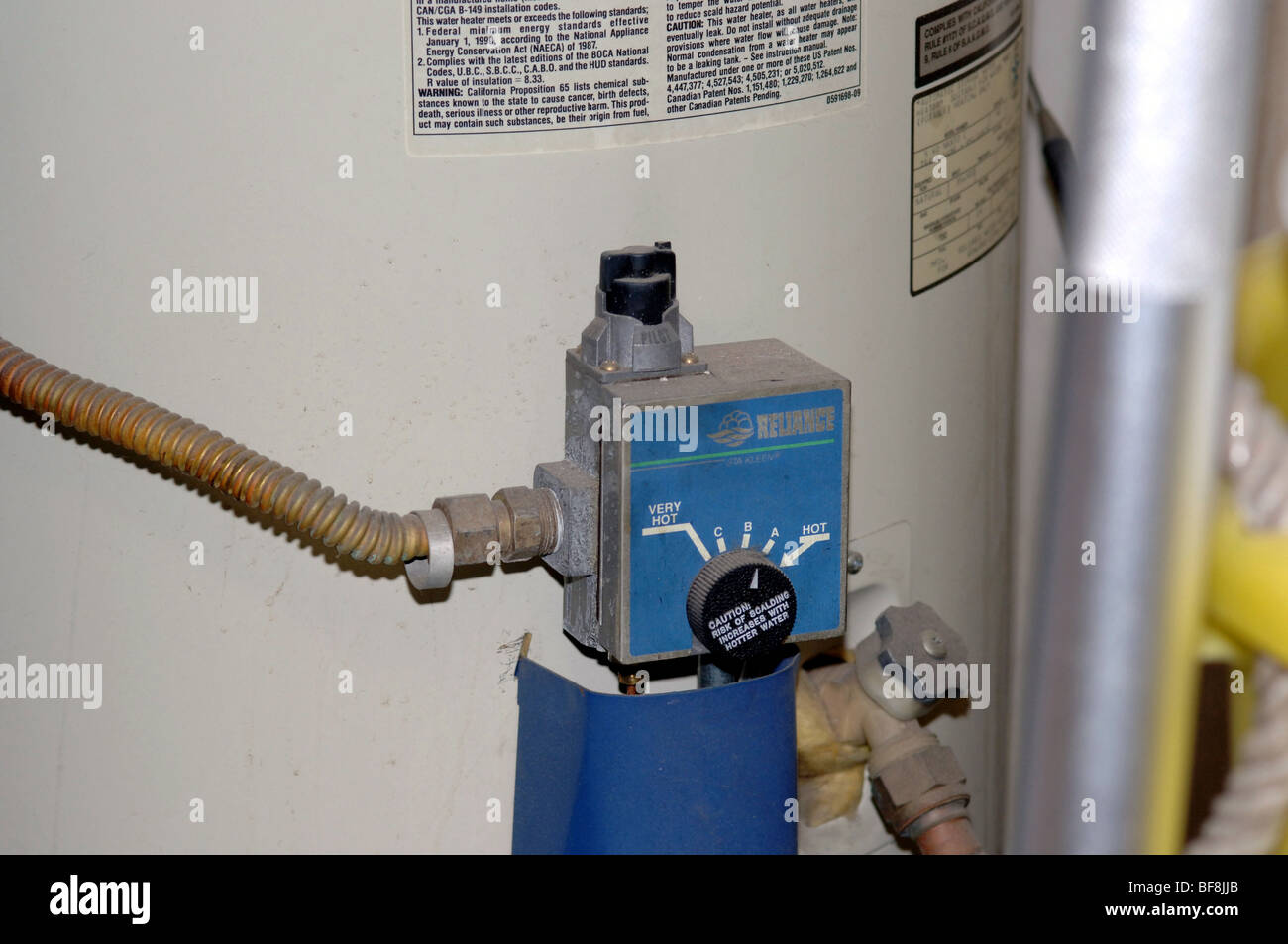 Water heater controls with flex gas line visible. Stock Photo