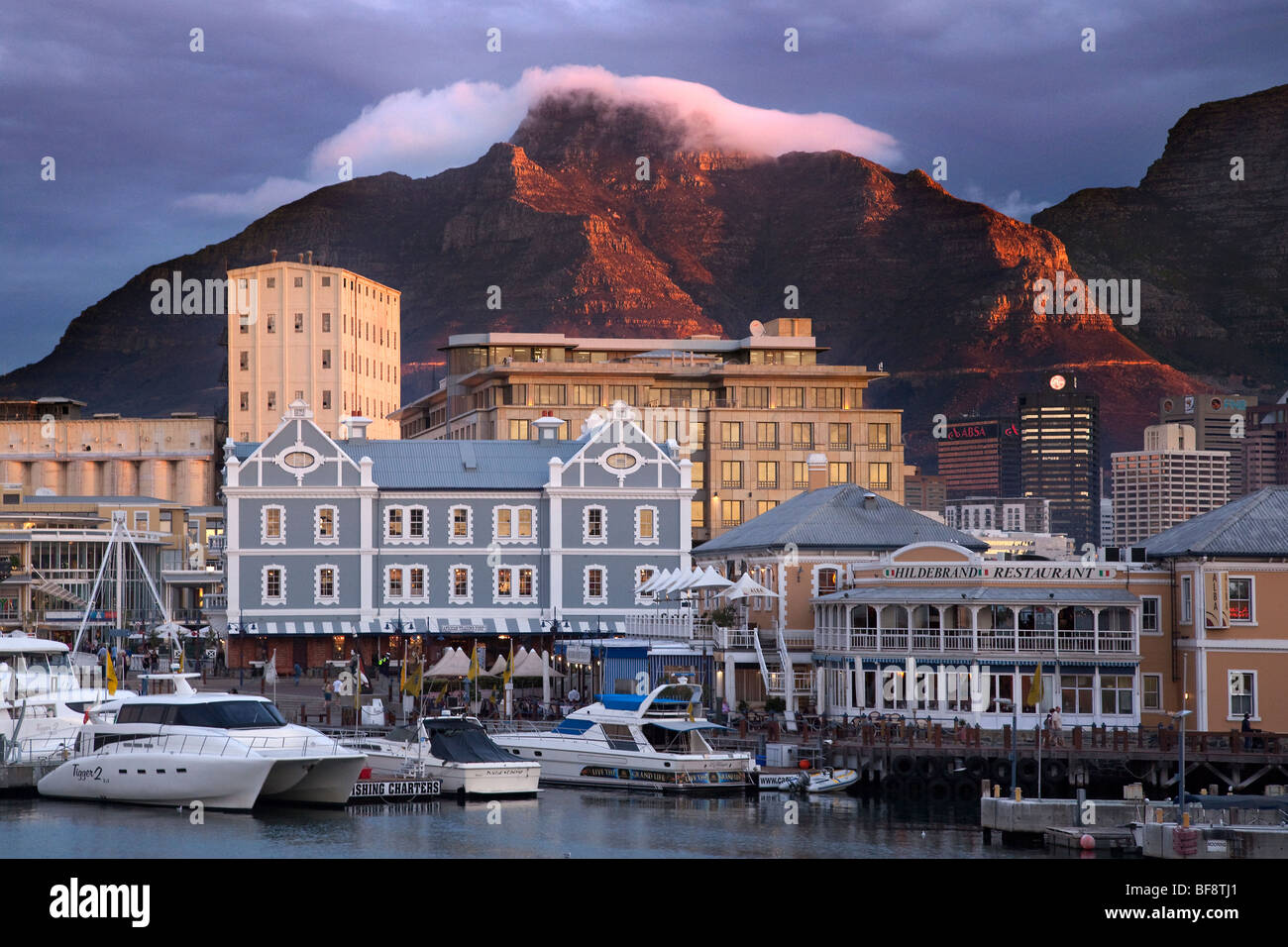 Cloud hangs over Table Mountain at sunset, the Victoria and Alfred Waterfront, Cape Town, South Africa Stock Photo