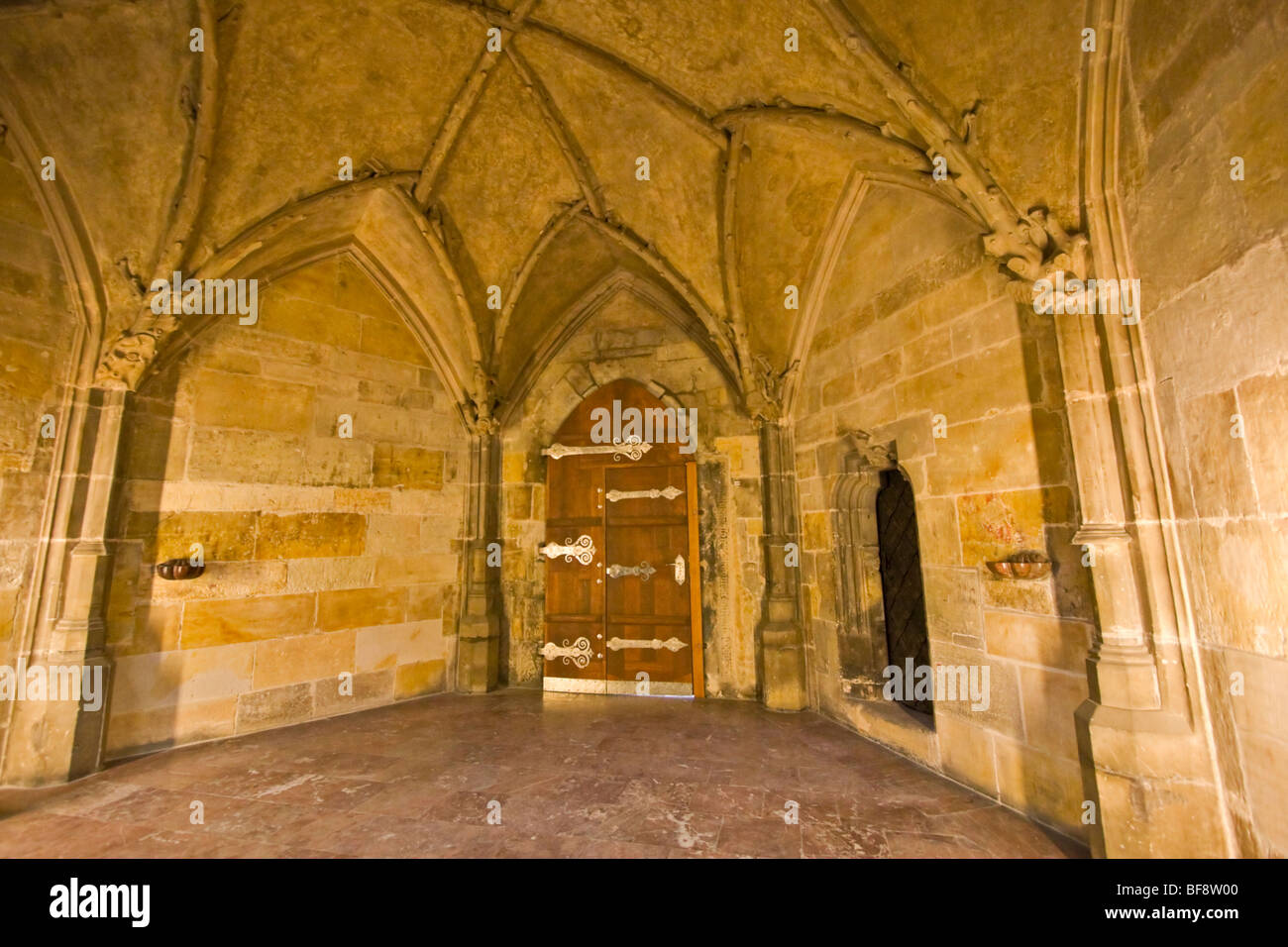 Alcove with vaulted ceiling and silver embellished arched wooden door