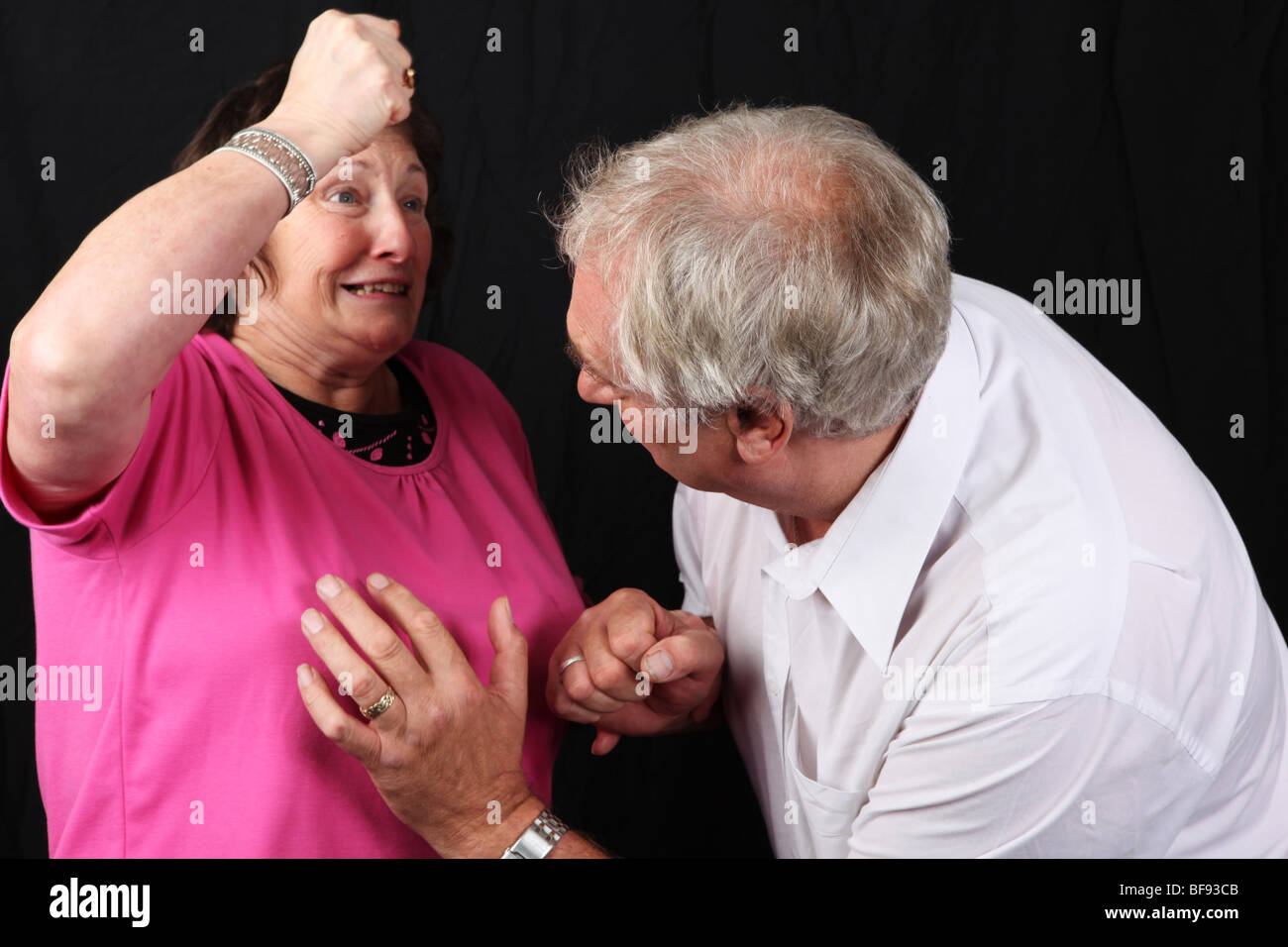 Late middle aged couple fighting wife beating husband battering punching  spousal abuse abusive relationship marriage Stock Photo