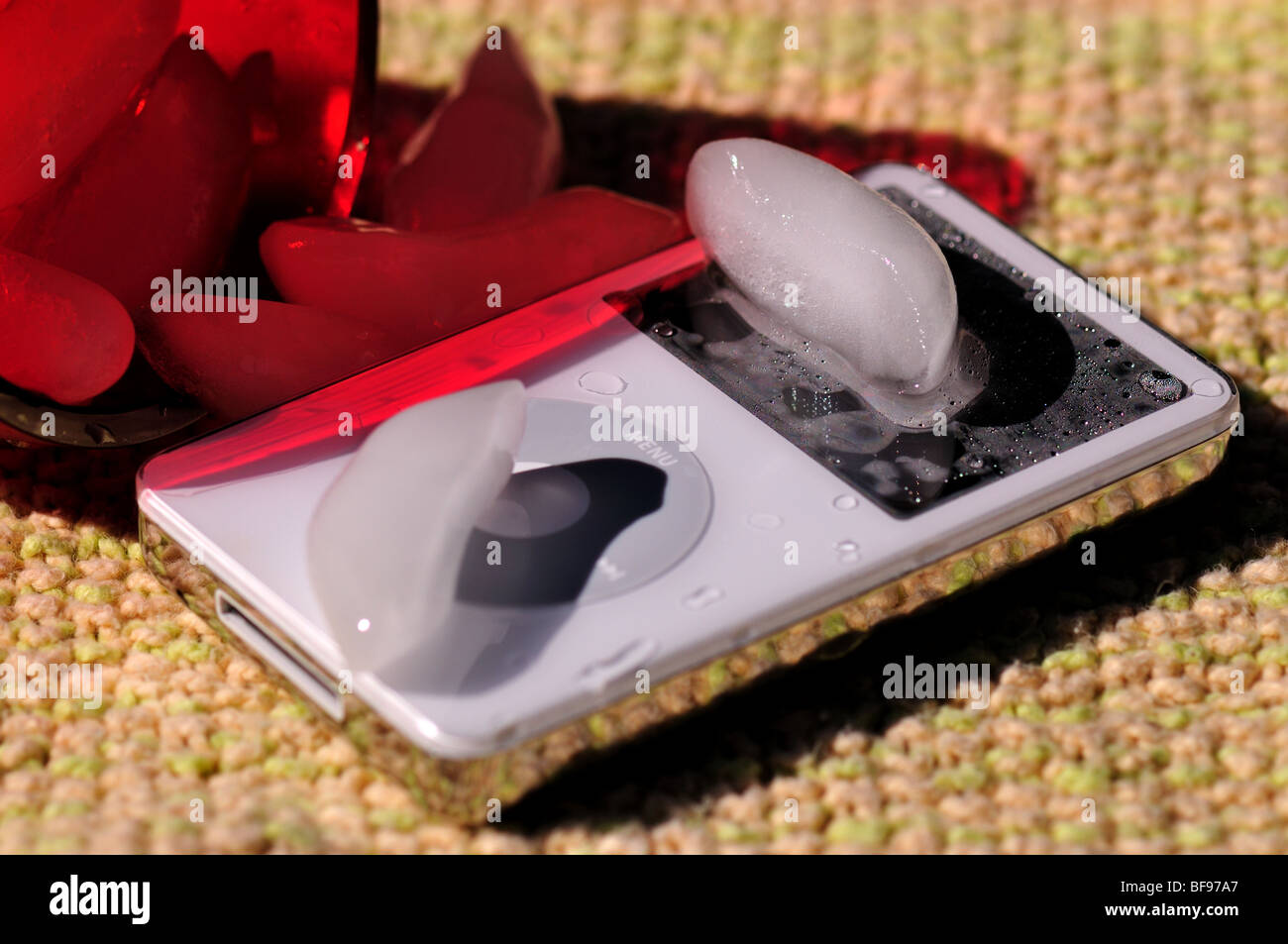 A glass of ice water spilled on an Ipod Stock Photo - Alamy