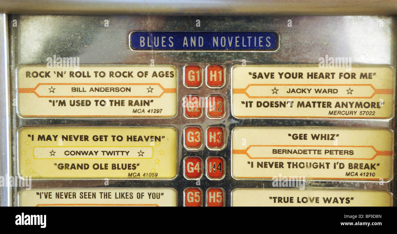 The display of an old jukebox offers a mix of old rock and roll and country songs in a small diner Stock Photo