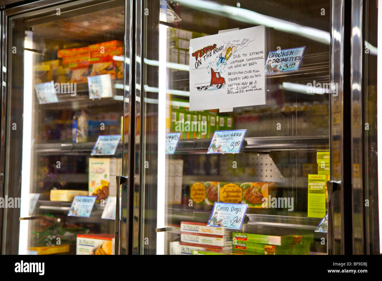 Empty freezer case in grocery store during snowstorm Stock Photo