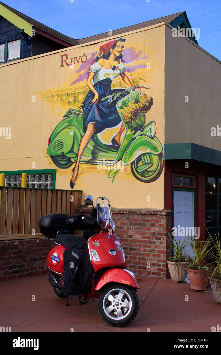 Red Vespa GTS parked under vintage scooter mural at Cafe Revo, Luna Park neighborhood of West Seattle, Seattle, Washington Stock Photo