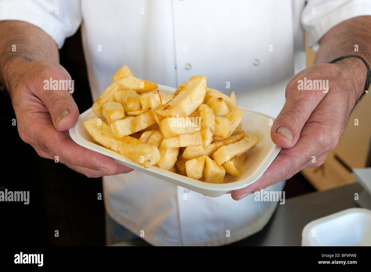 Serving of a portion of chips in chip shop, England, UK Stock Photo