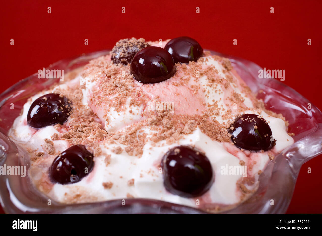 Chocolate ice-cream sundae with chocolate flake and a glazed cherry on top, served in a pretty glass. Stock Photo