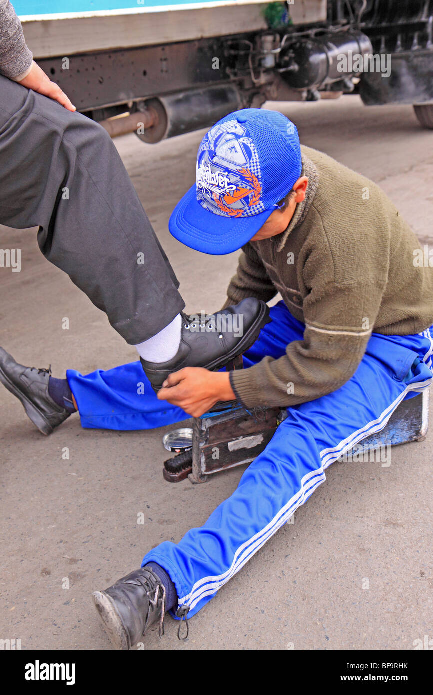 young boy shining shoes in the streets of Lima, Peru Stock Photo