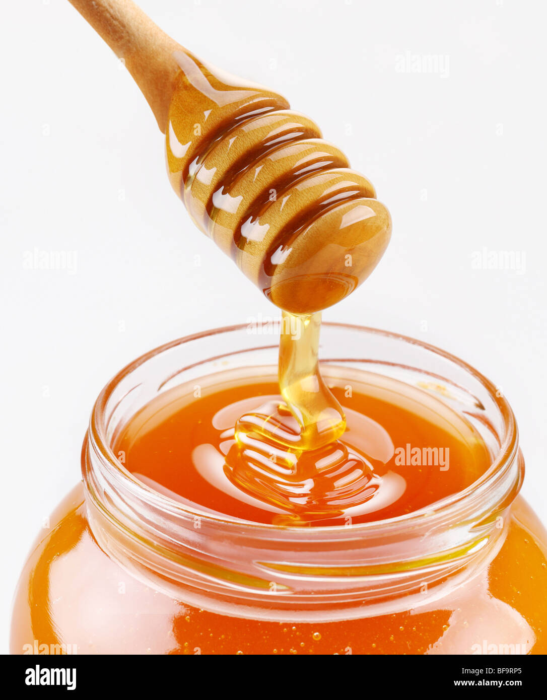 Honey dipper and full honey pot isolated on a white background Stock Photo
