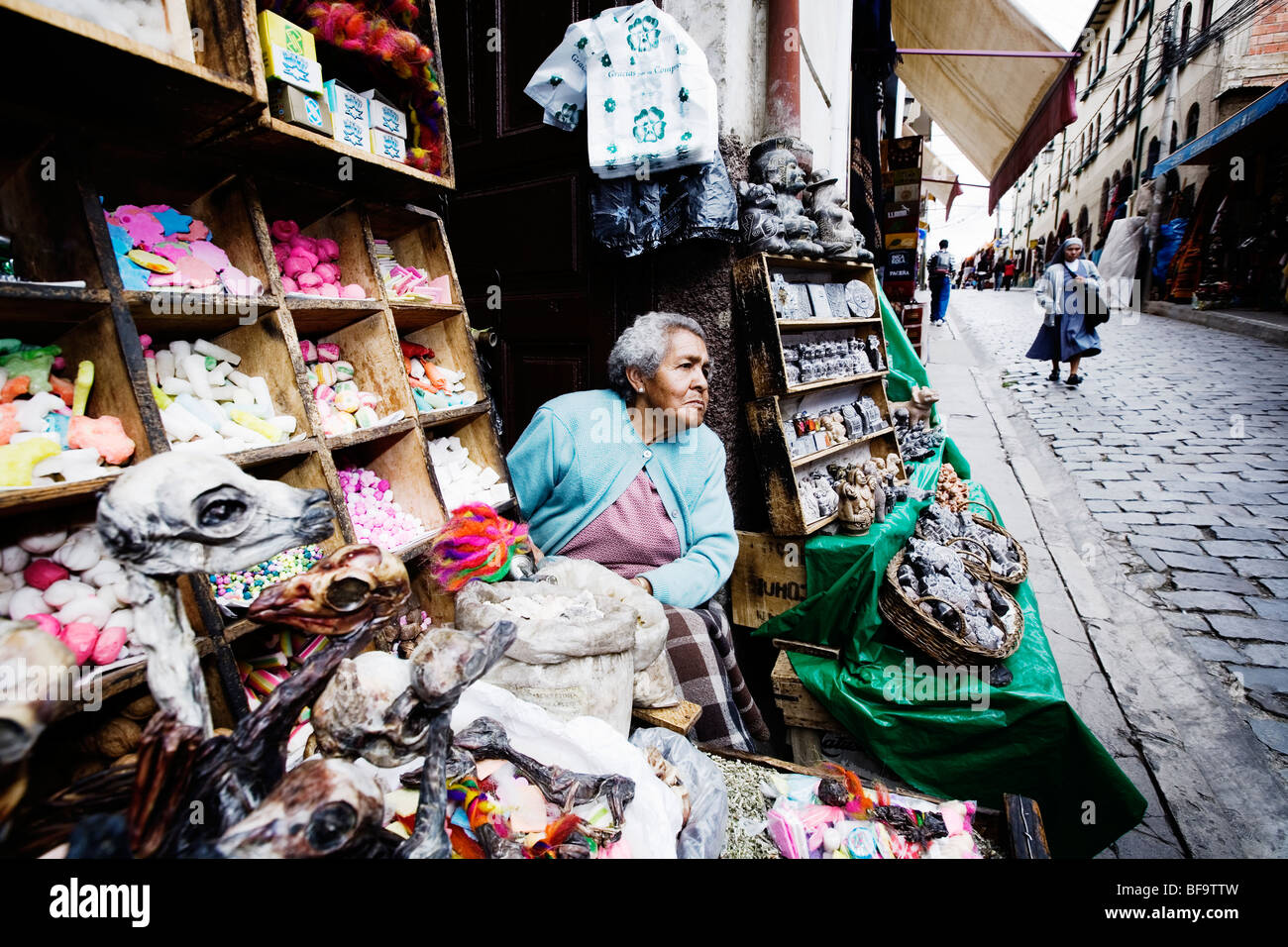 Old lady selling dried llama fetuses and other magical tools at Witch Market, La Paz, Bolivia. Stock Photo